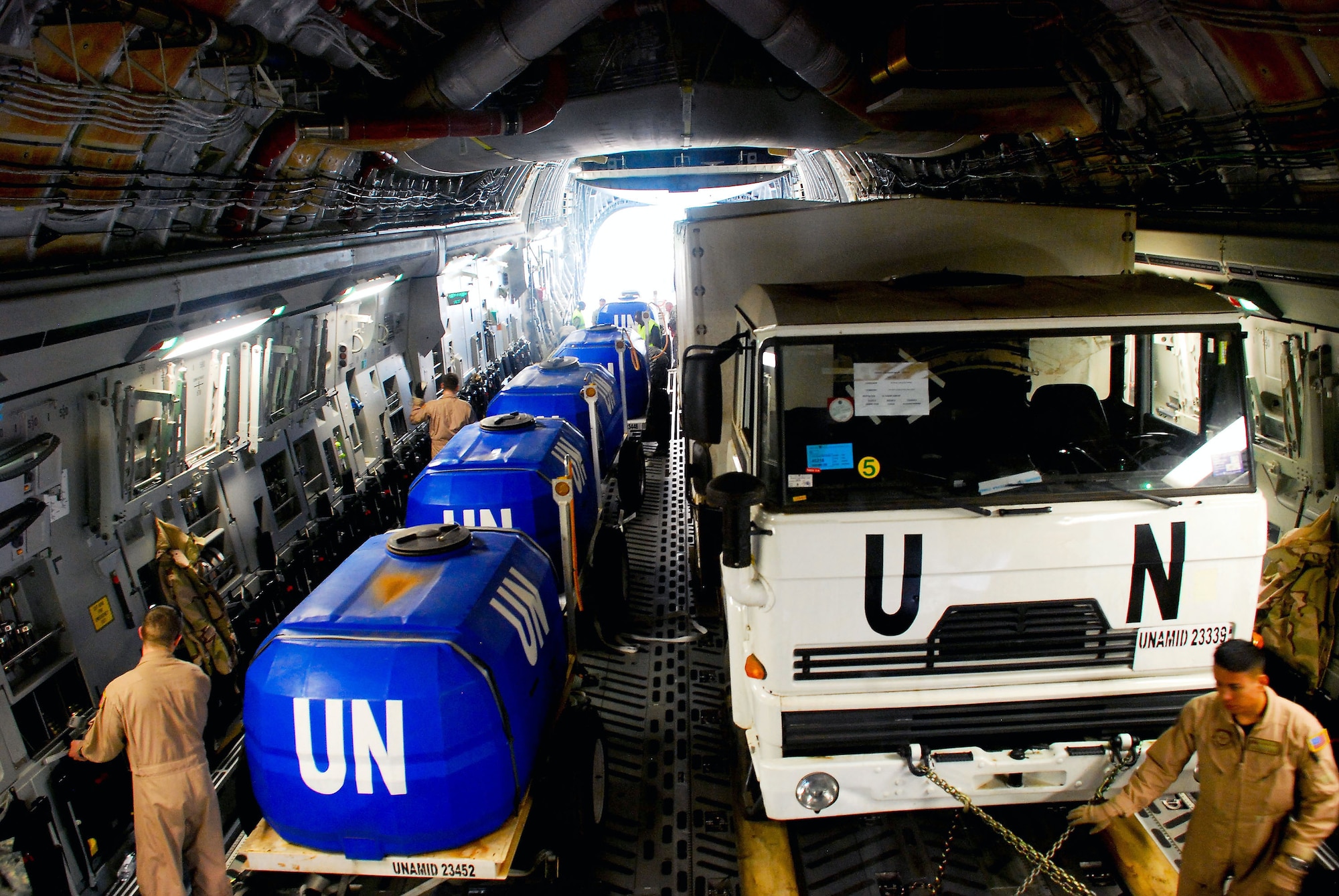 Loadmasters secure Rwandan defense force vehicles and water tanks on board a C-17 Globemaster III Jan. 13 at Kigali International Airport in Rwanda. This is the first load of five airlift missions to the United Nations Mission in Darfur. The Airmen are from Travis Air Force Base, Calif. (U.S. Air Force photo/Staff Sgt. Samuel Bendet) 
