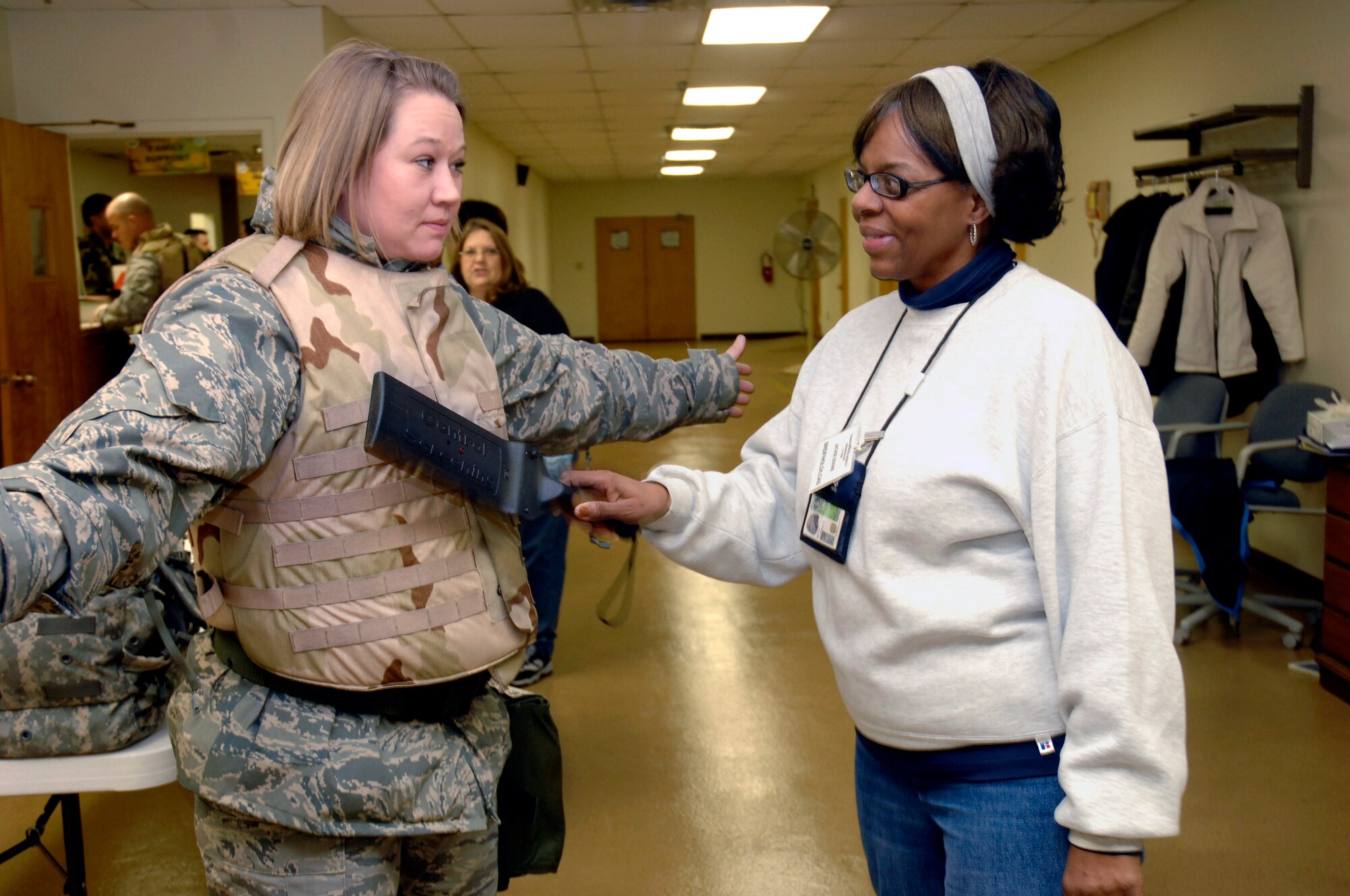 Tech. Sgt. Lisa Desantis, 88th Mission Support Squadron, receives a final security scan Jan. 13 by Jackie Bivins, a member of the Brief/Hold Load, at the Wright-Patterson Air Force Base Personnel Deployment Function.  The security scan was the last checkpoint before Airmen would wait to deploy in a holding area during a mobility exercise Jan. 12-14.  (U.S. Air Force photo/ Al Bright)