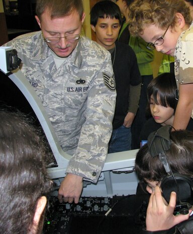 Tech. Sgt. Marshall Shepherd III, 372nd Training Squadron F-15 Trainer Development Team, teaches members of the Henderson Nevada Homeschool Group about the F-15E simulator during their tour of Det. 13 training facility Dec. 30. (Courtesy photo)
