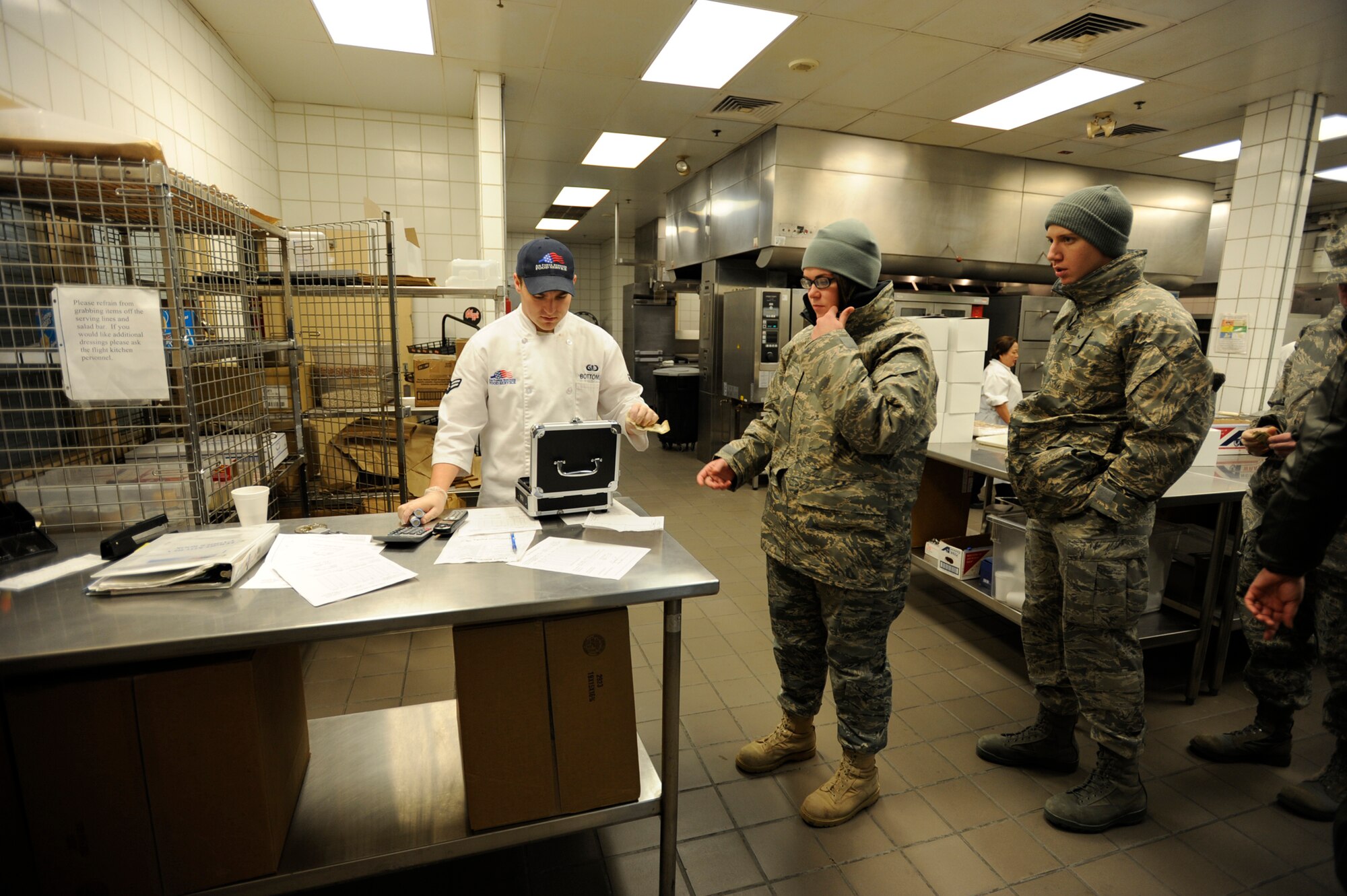 Airman 1st Class Falisha Styles pays Airman 1st Class Cody Bottoms for a boxed lunch from the McConnell Air Force Base dining facility in the early morning of Jan. 10. The lunch was for an air refueling mission Airman Styles and other Airmen from the 22nd Air Refueling Wing flew on that morning with a crew from the 931st Air Refueling Group, an  Air Force Reserve. The 22nd ARW is the 931st's active-duty host unit at McConnell. (U.S. Air Force photo/Tech. Sgt. Jason Schaap)