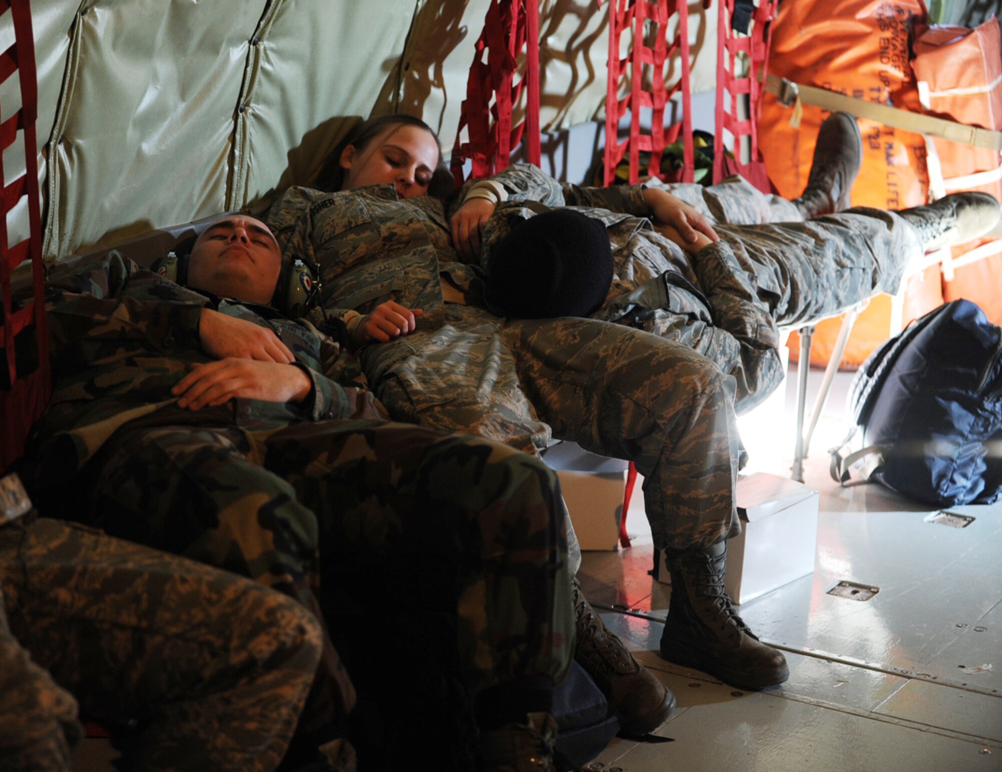 Three young Airmen assigned to the 22nd Aircraft Maintenance Group catch up on sleep during the flight back to McConnell Air Force Base, Kan. They and their fellow active-duty passengers climbed out of bed on a Saturday morning to be at McConnell by 6 a.m. for preflight briefs. The Airmen are, from left to right, Airman 1st Class Brad Evens, Airman Nikki Fisher and Airman 1st Class Luis Vasquez. (U.S. Air  Force photo/Tech. Sgt. Jason Schaap)