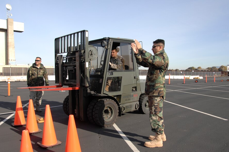 129th Aerial Port Flight personnel perform safety training at Moffett Federal Airfield, Jan. 4. Senior Airman Razvan Sonea operates a forklift while Staff Sgt. Felipe Mancera demonstrates safety procedures. The 129th Logistics Readiness Squadron’s Aerial Port Flight stood up Nov. 1, 2008. 129th Aerial Port personnel, also known as “Port Dogs,” are specialized Airmen trained to manage in-transit passenger and cargo movements for state directed missions and AEF deployments, redeployments, and exercises. (U.S. Air Force photo by Senior Airman Joshua Kauffman)(RELEASED)