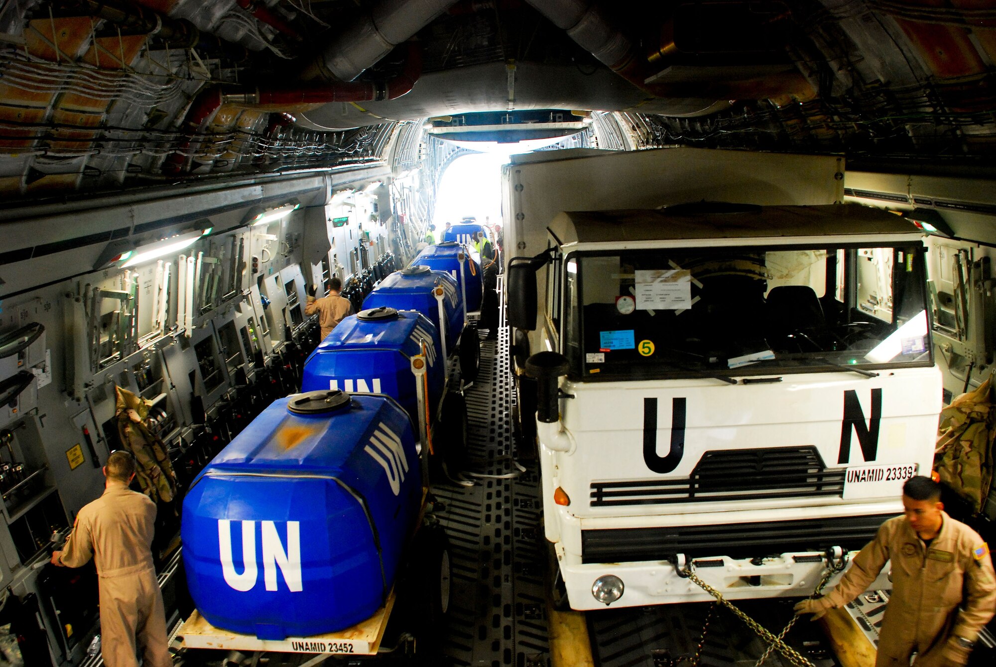 KIGALI INTERNATIONAL AIRPORT, Rwanda--Loadmasters from Travis AFB, Calif., secure the Rwandan Defense Force vehicles and water tanks on board a C-17 Globemaster III. This is the first load of five airlift missions to the United Nations Mission in Darfur. (Photo by Staff Sgt Samuel Bendet, US Africa Command)