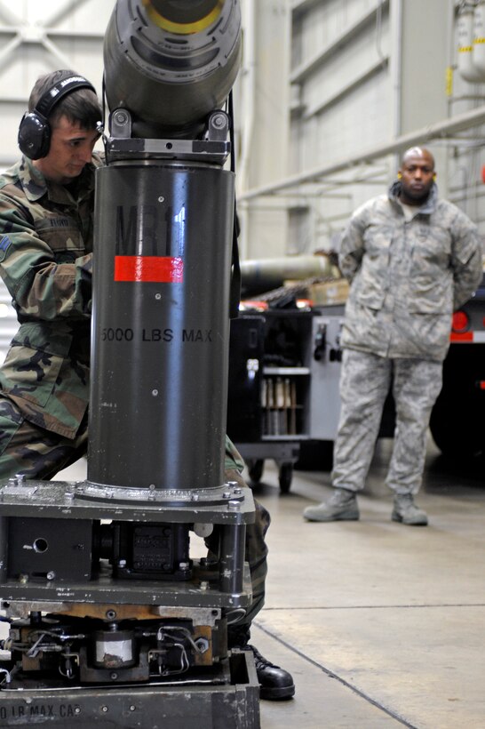 Airman 1st Class Anthony Floyd, 28th Maintenance Group weapons load apprentice, prepares a GBU-38 munition to be loaded into a B-1 armament systems trainer while Master Sgt. Eric Cornick, Air Combat Command Logistics Standardization and Evaluation Team armament superintendent views the process here Jan. 13.  The LSET teams ensure operations are conducted properly in all maintenance and logistics career fields. (U.S. Air Force photo/Airman 1st Class Matthew Flynn