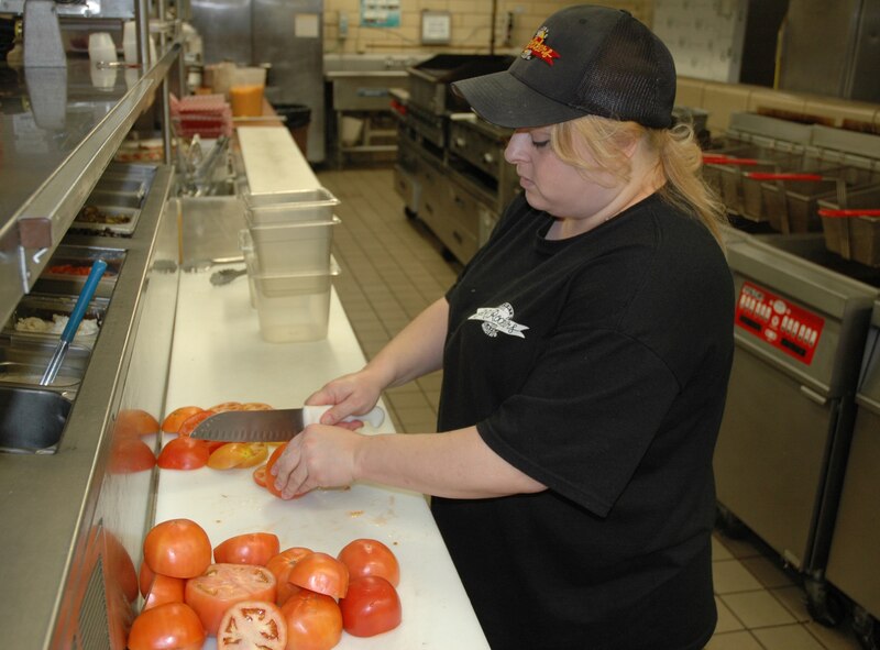 MINOT AIR FORCE BASE, N.D. -- Donna Naves, a cook at J.R. Rockers, slices up
tomatoes in preparation for lunch customers here Jan. 13. Rockers is a sports-themed restaurant that boasts almost 30 high definition televisions and features a menu that rivals some of the top large-chain restaurants in the United States. (U.S. Air Force photo by Senior Airman Wesley Wright)
