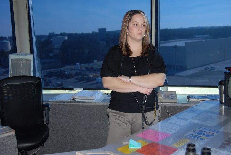 Christina Phorimavong, Air Traffic Control Watch Supervisor, listens to the other controllers take air traffic calls at the Pope tower Monday. As watch supervisor, Ms. Phorimavong listens to every position in the cab tower as way to ensure things are done safely and properly. (U.S. Air Force Photo by Airman 1st Class Mindy Bloem)