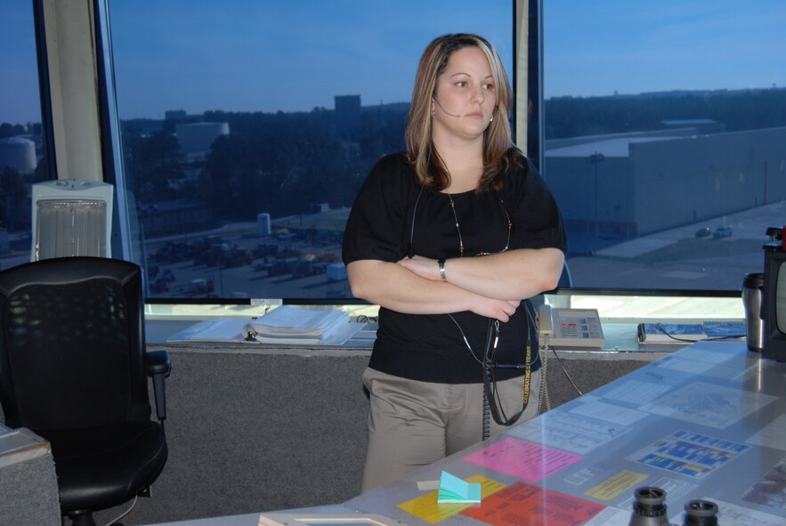 Christina Phorimavong, Air Traffic Control Watch Supervisor, listens to the other controllers take air traffic calls at the Pope tower Monday. As watch supervisor, Ms. Phorimavong listens to every position in the cab tower as way to ensure things are done safely and properly. (U.S. Air Force Photo by Airman 1st Class Mindy Bloem)