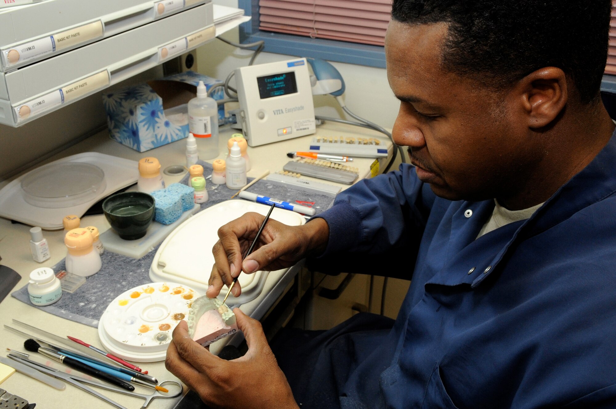 Tech. Sgt. Paul Foreman, 305th Dental Squadron lab technician, hand paints a porcelain partial denture to match Jan 9 at the Dental Clinic. The Dental lab has the latest state-of-the-art equipment; dentures now only take eight hours to make compared to the six weeks they used to take. (U.S. Air Force photo/Wayne Russell)