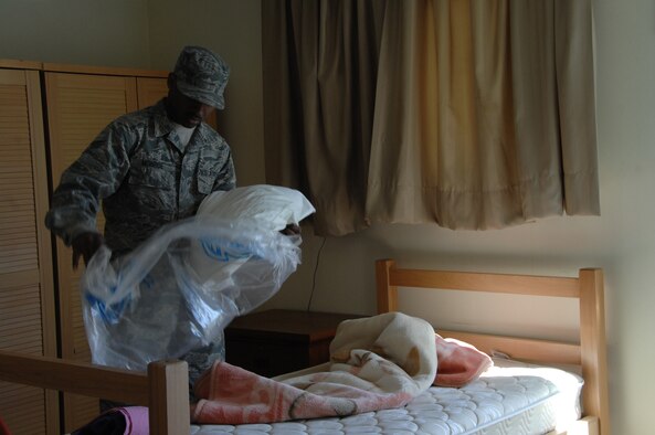 SOUTHWEST ASIA -- Senior Airman Maurice Monroe, 386th Expeditionary Force Support Squadron, removes a clean pillow from the package to place on a bed in the distinguished visitor trailer, Jan. 10, at an air base in Southwest Asia. Airmen in the 386th EFSS not only issue the rooms to all in-coming personnel, but also provide bedding and room maintenance. (U.S. Air Force photo/Senior Airman Courtney Richardson)
