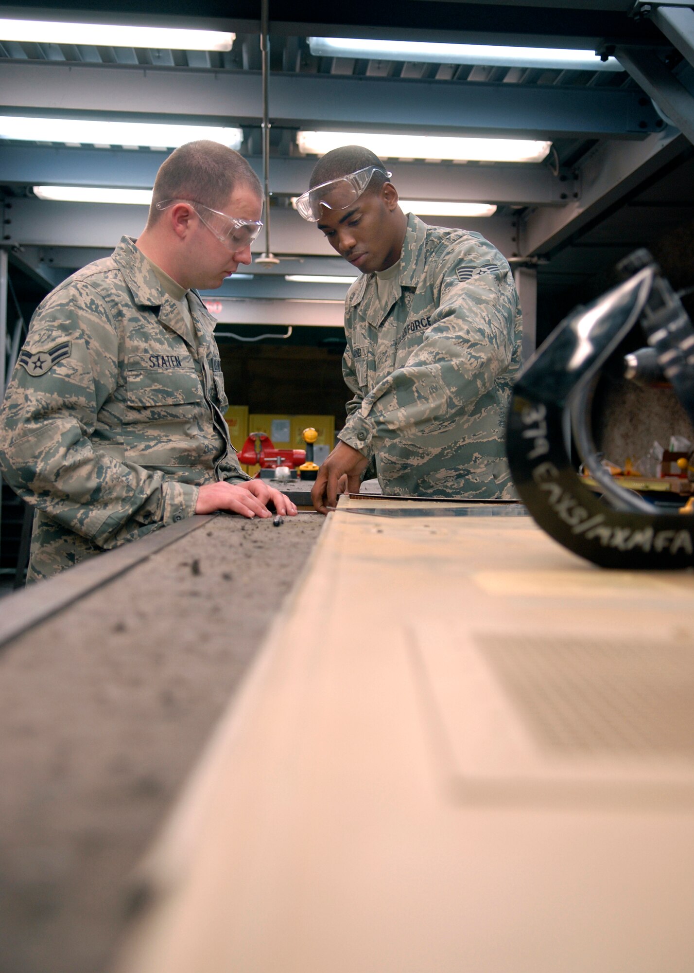 Staff Sgt. Cory Goines and Airman 1st Class Jeremy Staten, members of 379th Maintenance Squadron's Aircraft Structural Maintenance shop, measure sheet metal for a bonding repair on a P-3 Aircraft internal door, Jan. 13, 2009, at an undisclosed location in Southwest Asia.  Staff Sgt. Goines hails from Charlotte, N. C. and is deployed from Edwards Air Force Base Calif and Airman 1st Class Staten hails from Carriere, Miss. and is deployed from Tinker Air Force Base, Okla.  Airmen in the sheet metal shop work on a variety of aircraft from C-130's to KC-135's in support of Operation Iraqi and Enduring Freedom, and Joint Task Force- Horn of Africa.  (U.S. Air Force Photo by Airman 1st Class Andrew Satran/Released)