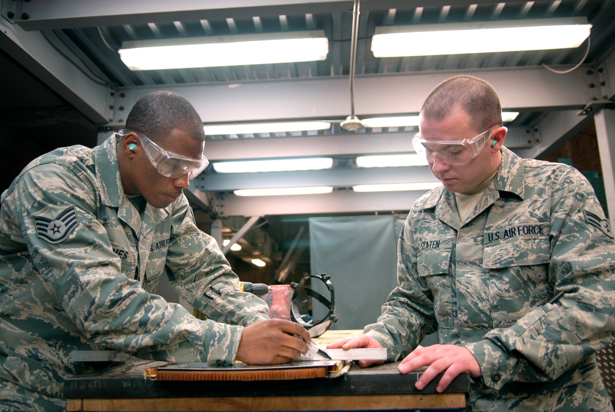 Staff Sgt. Cory Goines and Airman 1st Class Jeremy Staten, members of 379th Maintenance Squadron's Aircraft Structural Maintenance shop, measure sheet metal for a bonding repair on a P-3 Aircraft internal door, Jan. 13, 2009, at an undisclosed location in Southwest Asia.  Staff Sgt. Goines hails from Charlotte, N. C. and is deployed from Edwards Air Force Base Calif and Airman 1st Class Staten hails from Carriere, Miss. and is deployed from Tinker Air Force Base, Okla.  Airmen in the sheet metal shop work on a variety of aircraft from C-130's to KC-135's in support of Operation Iraqi and Enduring Freedom, and Joint Task Force- Horn of Africa.  (U.S. Air Force Photo by Airman 1st Class Andrew Satran/Released)