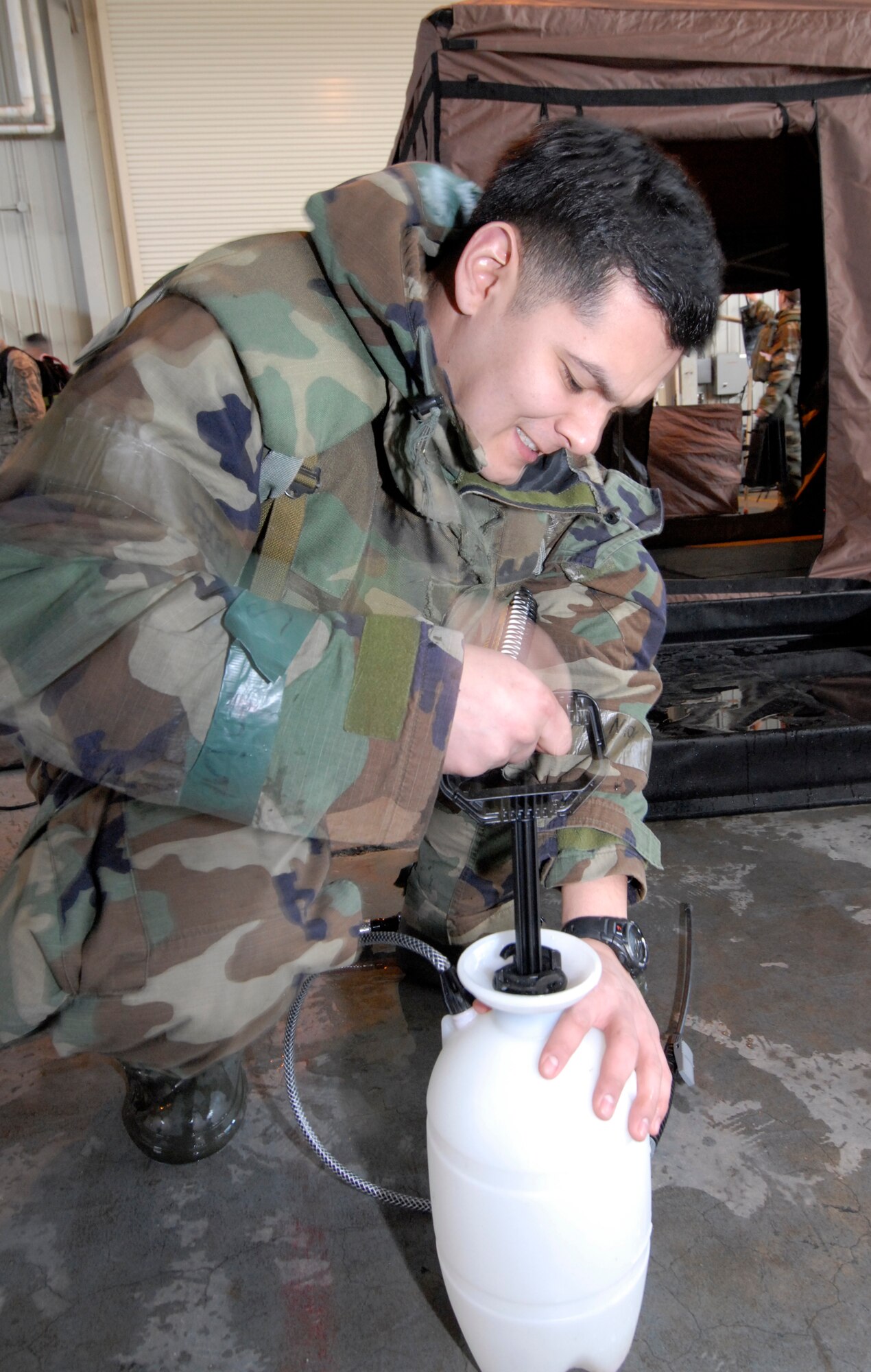 Senior Airman Andres Aponte, 8th Comptroller Squadron, pressurizes a spray bottle in preparation for decontamination of contaminated individuals during the Peninsula-Wide Operational Readiness Exercise at Kunsan Air Base, Republic of Korea, Jan. 14, 2009. Airman Aponte is a part of the Trained Controlled Contamination Area team where he helps process contaminated individuals through the CCA.(U.S. Air Force Photo by Senior Airman Dana Hill)