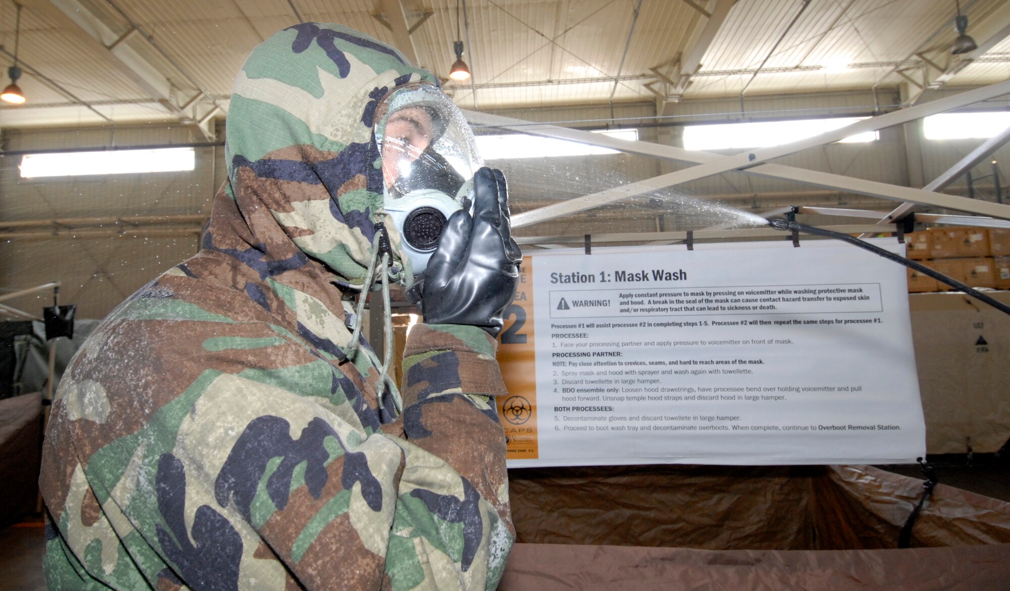 A member of the 8th Fighter Wing gets their gas mask washed and freed of contamination while processing through a Contamination Control Area during the Peninsula-Wide Operational Readiness Exercise at Kunsan Air Base, Republic of Korea, Jan. 14, 2009. The CCA is used to process contaminated individuals from a contaminated chemical environment to a non-contaminated chemical environment. (U.S. Air Force Photo by Senior Airman Dana Hill) 