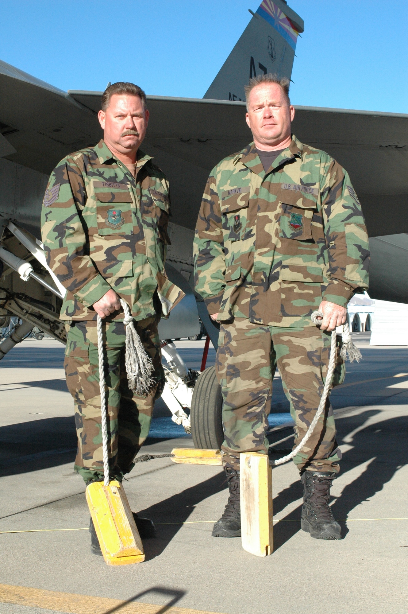 Tech Sgt. Daniel Tibbitts (left), Staff Sgt. Michael Markve (right) and Tech. Sgt. Jaime Aviles (not pictured) earned the Air Force and Air Education and Training Command Safety Well Done Awards for saving this F-16 from a mishap last year. The three crew chiefs, assigned to the Arizona Air National Guard's 162nd Fighter Wing, used chocks to stop the aircraft when loss of hydraulic pressure in the braking system caused it to meander uncontrollably on the flightline here. (Air National Guard photo by Staff Sgt. Desiree Twombly)
