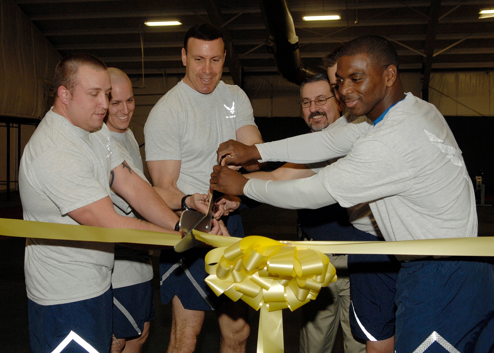 Colonel Steven Shepro, 316th Wing commander, and fellow Airmen of the Andrews community cut a ceremonial ribbon to commemorate the opening of the new Tactical Fitness Center Jan. 15. Commanders, superintendents and Team Andrews members gave their best in the inaugural exercise session at the Tactical Fitness Center. The program builds core strength and endurance that are fundamental to a superior level of combat fitness, both as indiviuals and teams. The new Tactical Fitness Center replaces the multi-purpose room at the West Fitness Center. Class schedules will be posted at the main entrance of the fitness center, and individuals can work out in the the new TFC during normal operations. (U.S. Air Force photo by Senior Airman Melissa Stonecipher)