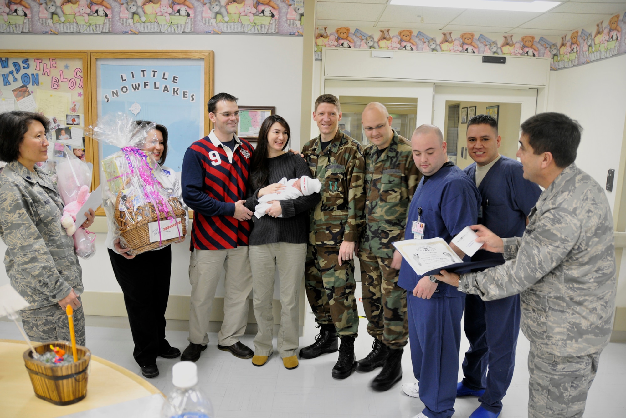 MISAWA AIR BASE, Japan -- Col. Guillermo Tellez, 35th Medical Group commander, presents a birth certificate Jan. 9 for Evera Moore, daughter of Navy Lt. Hyatt Moore, Navy Information Operations Command, and his wife, Nicole, after giving birth Jan. 8 to the first baby born on Misawa Air Base in 2009. Anna Iosefo, Misawa Army and Air Force Exchange Services general manager, presented gifts to the couple to celebrate their newborn daughter. (U.S. Air Force photo by Senior Airman Chad Strohmeyer)