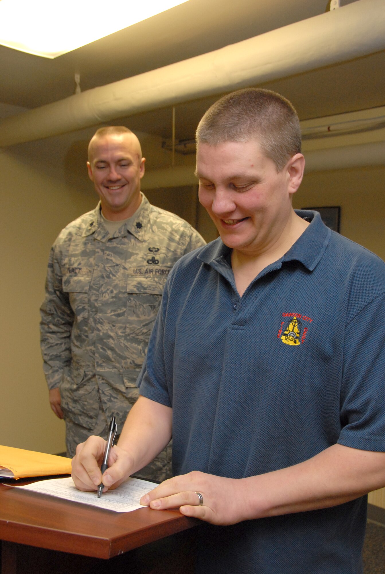 Derrick Bell signed his enlistment paperwork Jan. 15 with Lt. Col. Raymond Platt.  Bell is the newest enlisted member of the 477th Fighter Group, a Classic Associate unit responsible for recruiting, training, developing and retaining unrivaled Citizen Airmen.  In only 11 months Bell lost 115 pounds before he met physical standards for the Air Force Reserve.  Today he is preparing to attend technical training to work as an F-22A Raptor Crew Chief. (U.S. Air Force photo by Staff Sgt. Rhiannon Willard)