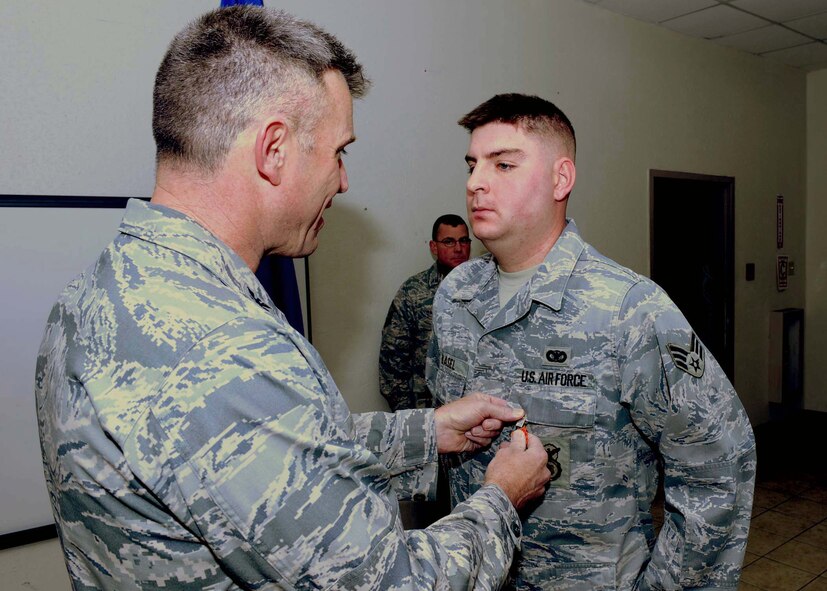 DYESS AIR FORCE BASE, Texas -- Colonel Robert Gass, 7th Bomb Wing Commander, presents Senior Airman Gerald Basel, 7th Security Forces Squadron, with the Air Force Combat Action Medal during a medal presentation here, Jan. 13. Airman Basel earned the medal for his engagement against insurgents while deployed to Iraq. (U.S. Air Force photo by Airman 1st Class Stephen Reyes)