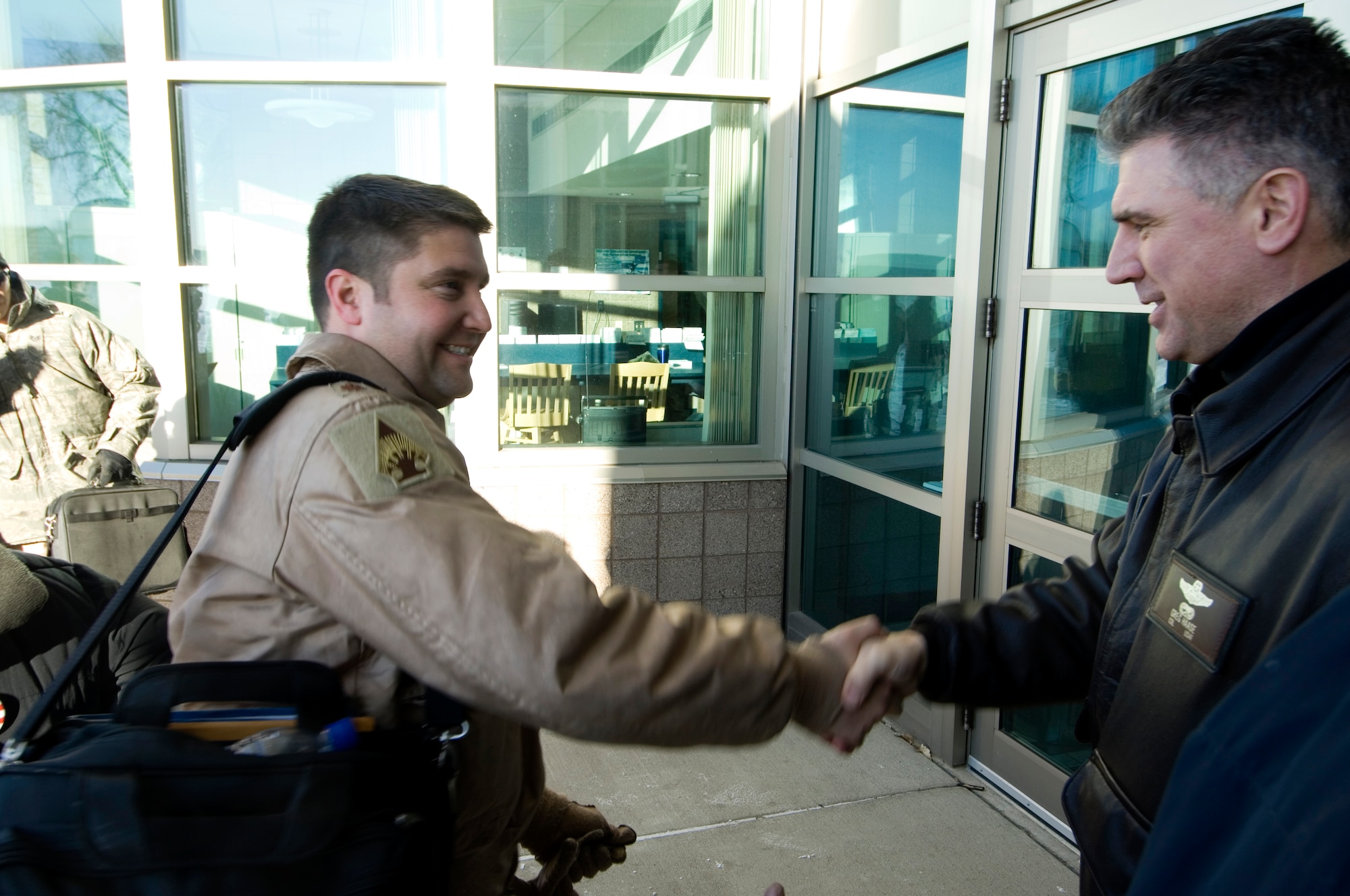 133rd Airlift Wing Commander Colonel Greg A. Haase (right) shakes hands with  Maj. Jeffrey Wong (left) upon arrival at the 133rd Operations building 14 January 2009. Major Wong piloted the Minnesota Air National Guard C-130 Hercules that returned from deployment to Afghanistan supporting Operation Enduring Freedom. (U.S. Air Force photo/Tech. Sgt. Erik Gudmundson) 