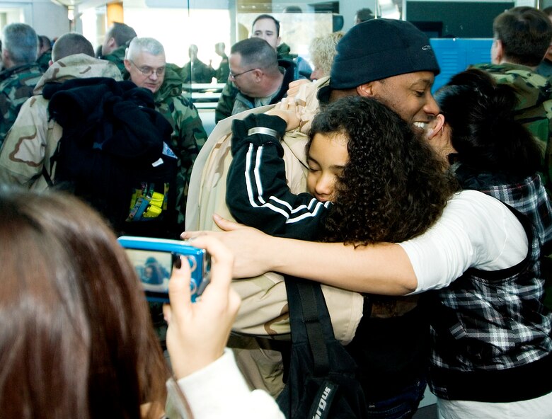 Master Sgt Anthony Harrington a loadmaster with the 109th Airlift Squadron receives a group hug from his family upon return to Minnesota. Harrington was one of 29 members of the 133rd Airlift Wing Minnesota Air National Guard to return from deployment to Bagram Air Field, Afghanistan 14 January 2009. (U.S. Air Force photo/Tech. Sgt. Erik Gudmundson) 