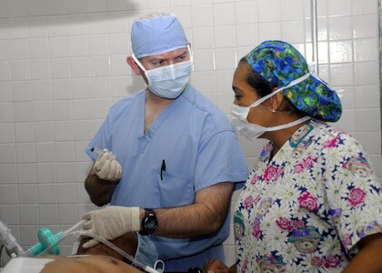 SOTO CANO AIR BASE, Honduras - Air Force Certified Registered Nurse Anesthetist Lt. Col. Ritchie Grissett consults with a local anesthetist from Dr. Roberto Suazo Cordova Hospital during an operation Jan. 13.  A four-person surgical team from U.S. Southern Command's Joint Task Force-Bravo conducted two operations in La Paz as part of regularly scheduled Medical Readiness Training Exercises.  (US Air Force photo/Tech. Sgt. Rebecca Danét)