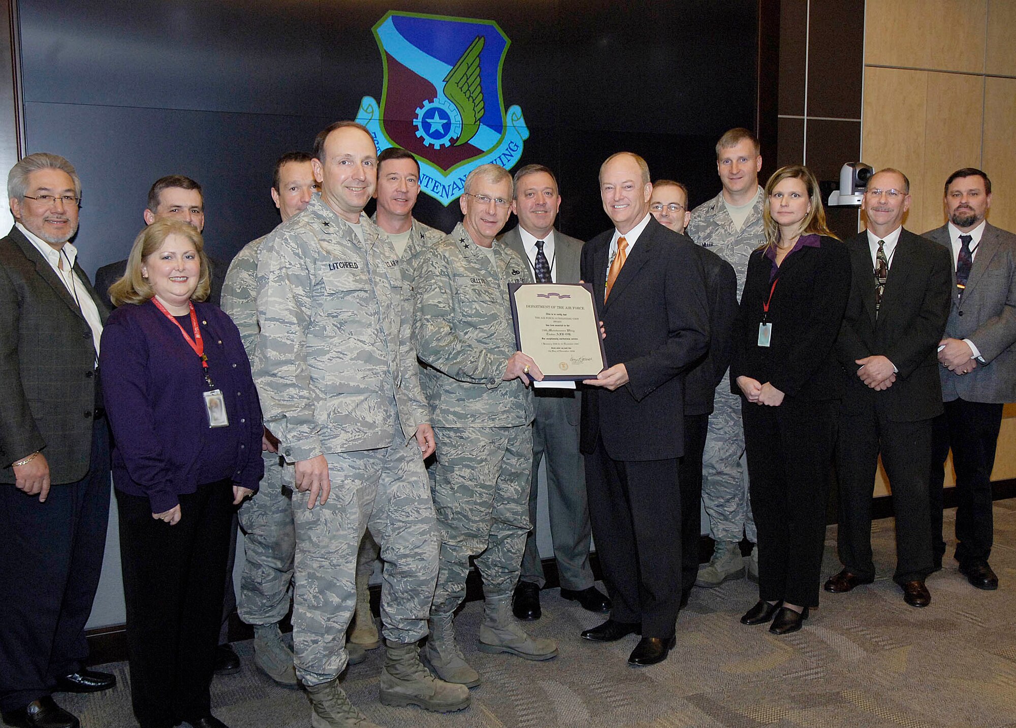 The first order of business for Oklahoma City Air Logistics Center Commander Maj. Gen. P. David Gillett Jr. during his orientation briefing with the 76th Maintenance Wing, was to present them with an Air Force award Wednesday.  Surrounded by wing, group and squadron commanders and staff, 76th Maintenance Wing Vice Director James Patterson accepts the award from General Gillett on behalf of the wing and commander, Brig. Gen. Bruce Litchfield. The Outstanding Unit Award credited the wing’s distinguished accomplishments from Jan. 1, 2006, through Dec. 31, 2007, repeatedly citing setting delivery records in support of the warfighter. (Air Force photo/Margo Wright)