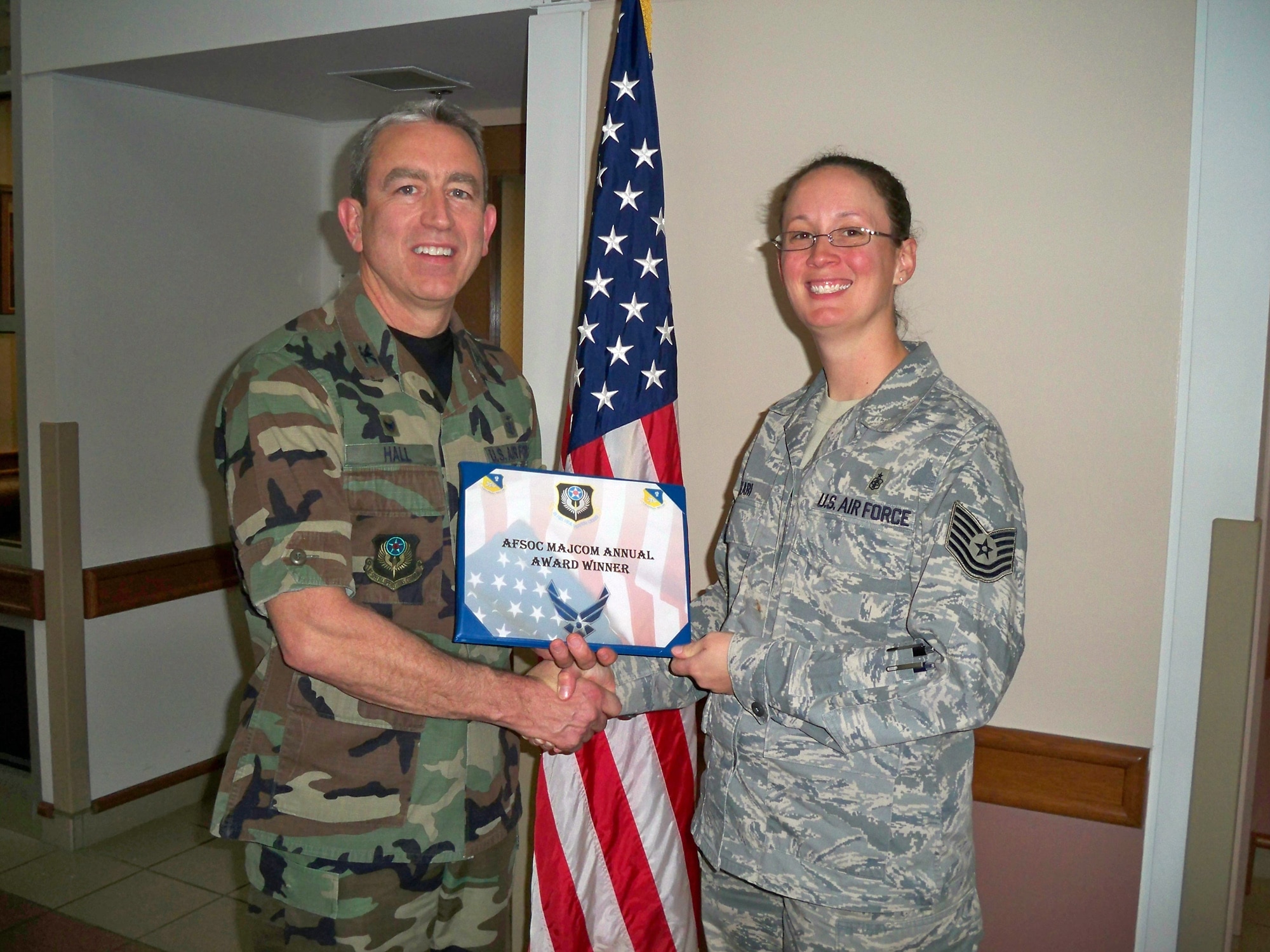 CANNON AIR FORCE BASE, N.M.-- Col. Kenneth Hall, 27th Special Operations Medical Group commander, presents Tech. Sgt. Jolynn Kari with the 2008 Air Force Special Operations Command Medical Readiness noncommissioned officer on Jan 8. Sgt. Kari was also nominated for the USAF Outstanding Medical Readiness NCO of the Year Award. (courtesy photo)