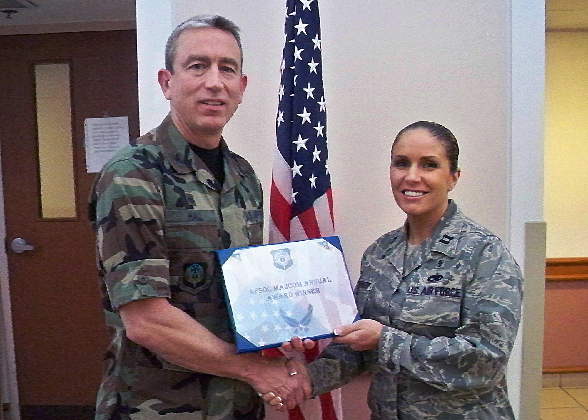 CANNON AIR FORCE BASE, N.M. -- Col. Kenneth Hall, 27th Special Operations Medical Group commander, presents Capt. Jennifer Devenere, 27th SOMDG, with the 2008 Air Force Special Operations Command Outstanding Young Helath Care Administrator Award, at the medical clinic on Jan. 8. Capt. Devenere was also nominated for the Brigadier General Peter C. Bellisario Young Health Care Administrator of the Year Award.  (Courtesy photo) 