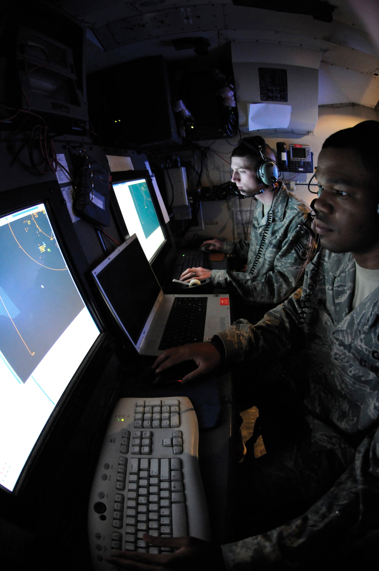 Staff Sgt. Odell Straughter III and Staff Sgt. Randy Bowser set up and maintain a tactical data link Dec. 30, 2008, in Southwest Asia. Sergeant Straughter III is a weapons director assigned to the 71st Expeditionary Air Control Squadron. He hails from St. Louis. Sergeant Bowser is an interface control technician assigned to the 71st EACS. He is a native of New Britian, Conn. (U.S. Air Force photo/Tech. Sgt. Michael Boquette) 
