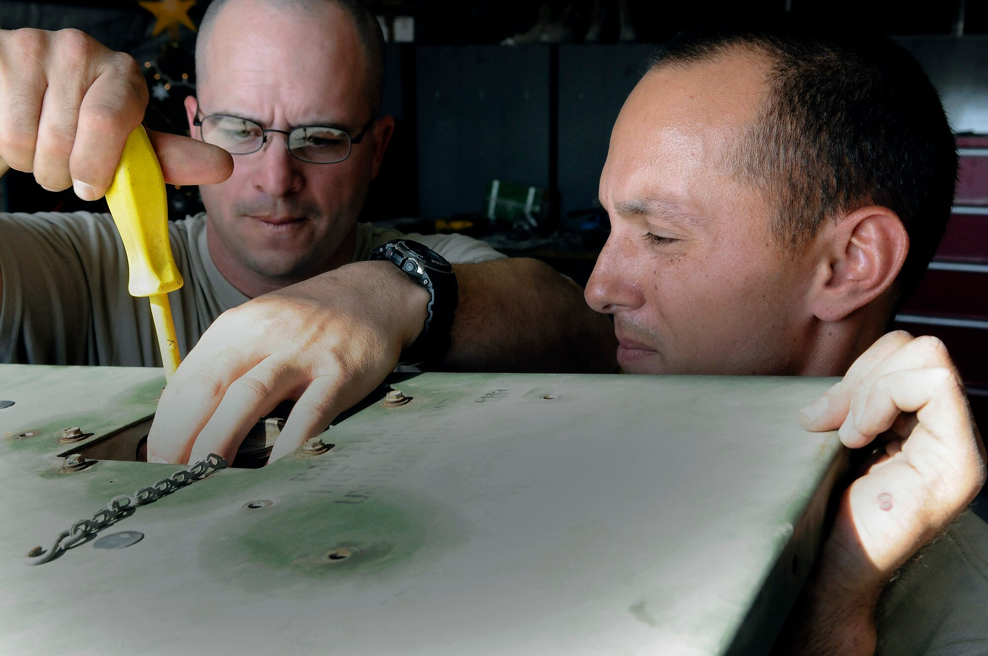 Technical Sgt. Andrew Ferguson tightens a connection while Senior Airman Craig Stawicki holds the top in place Dec. 30, 2008, in Southwest Asia. The maintainers, electrical power plant production technicians assigned to the 71st Expeditionary Air Control Squadron, are responsible for servicing the generators that keep the 71st EACS radars up and running. Sergeant Ferguson is a native of Colt, Ark., and Airman Stawicki hails from Brick, N.J. (U.S. Air Force photo/Tech. Sgt. Michael Boquette) 