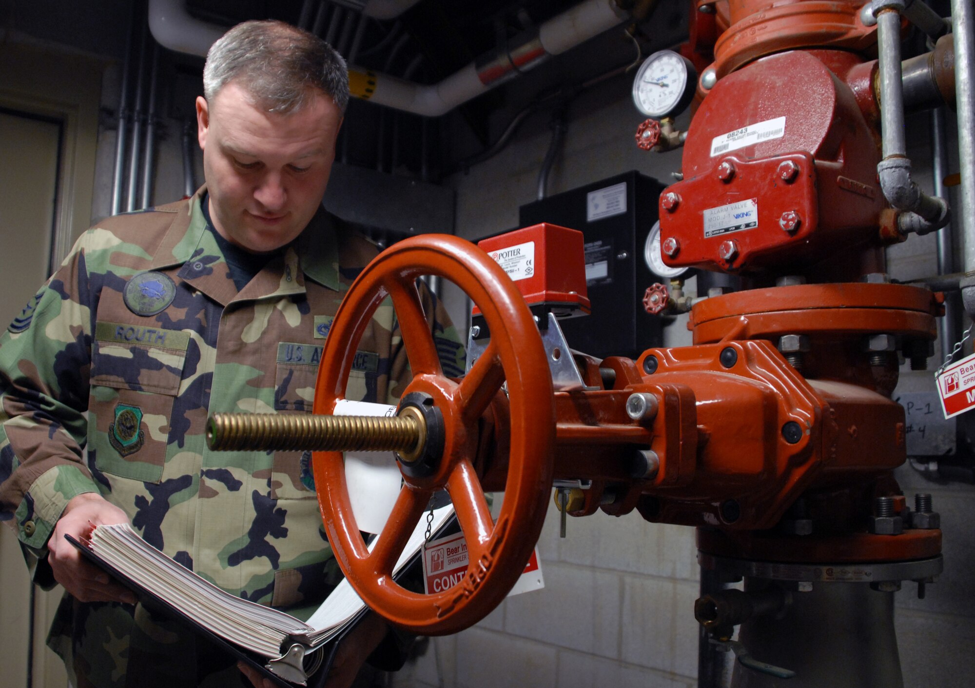 Tech. Sgt. Michael Routh, a 436th Civil Engineer Squadron Fire Prevention officer and volunteer fire fighter in the local community, utilizes binders full of building codes to perform a routine inspection on Dover Air Force Base Jan. 14. Sergeant Routh stresses that more fires occur during the winter months than any other time of the year and hopes that with proper training, guidance and inspections, all of Team Dover may remain safe this winter and all year round. (U.S. Air Force photo/Tech. Sgt. Kevin Wallace)