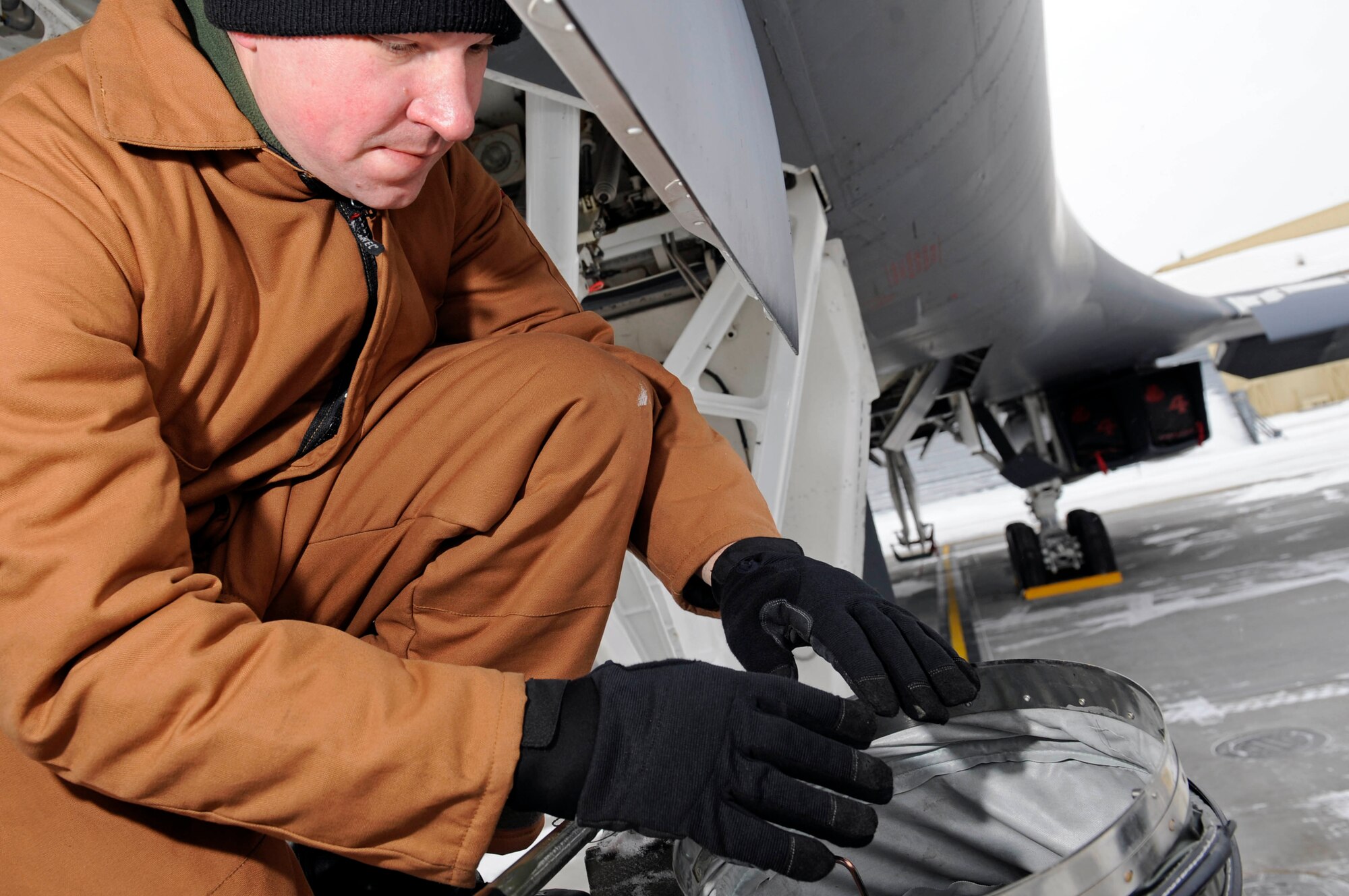 Staff Sgt. Joseph Canet, 28th Aerospace Maintenance Squadron dedicated crew chief, takes a moment to warm his hands with a heating hose here, Jan. 15. Maintainers use heating hoses to keep warm while working on the flightline during adverse weather conditions. (US Air Force photo/Airman 1st Class Corey Hook)