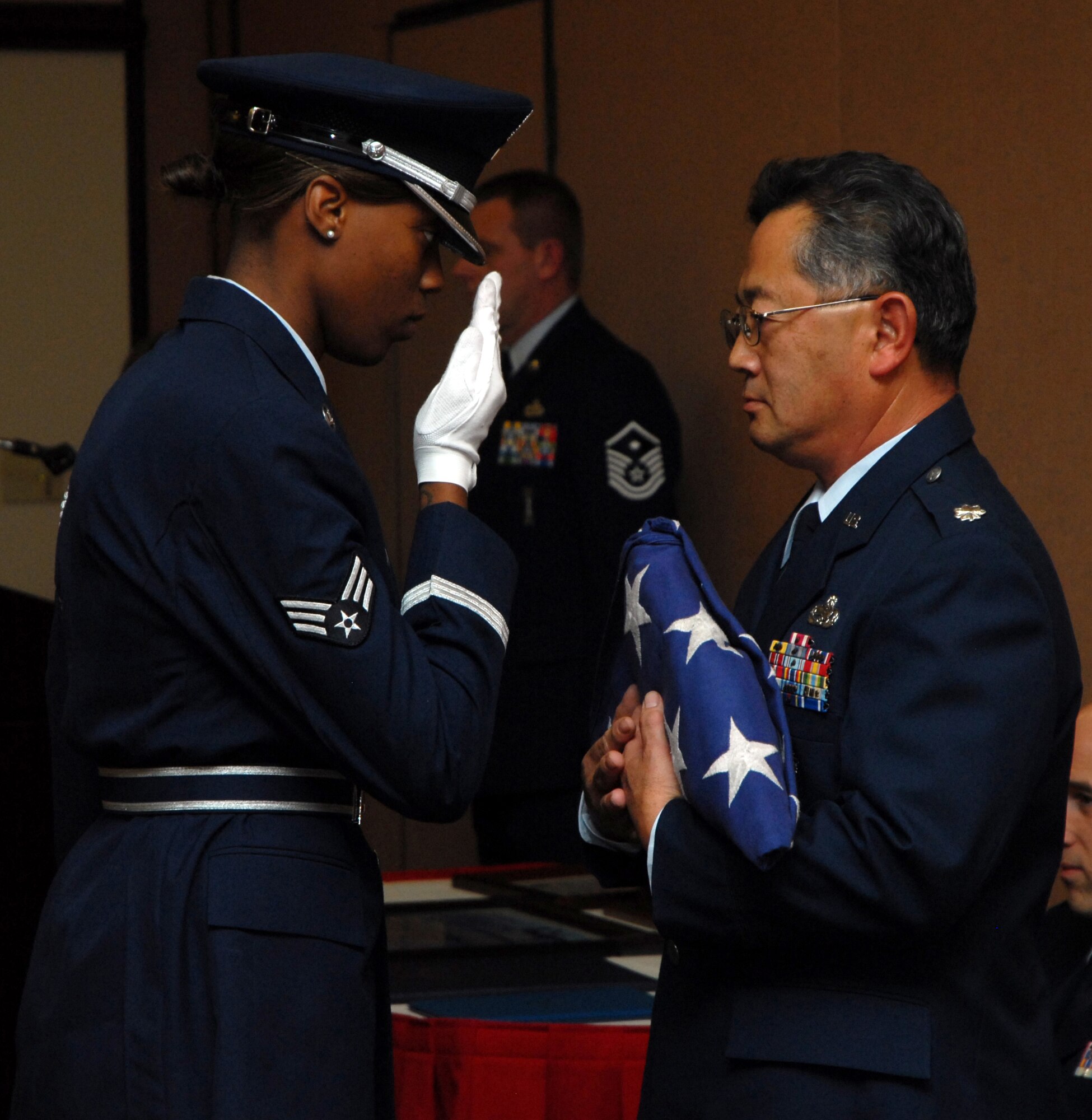BEALE AIR FORCE BASE, Calif. -- Inspector General of the 940th Air Refueling Wing, Air Force Reservist Lt. Col. Djoko Soejoto receive the American flag from a member of the Beale AFB Honor Guard during his retirement ceremony here, Jan. 10, 2009. Lt. Col Soejoto retired from the Air Force Reserve after 31 years of honorable service. All members of the U.S. armed forces, which include Guard and Reserve, are entitled to a retirement flag.  The ceremony also marked a historical milestone for the wing, as it was the first retirement for the 940th ARW wing commander, Col. Jeffrey "Sal" Mineo. (U.S. Air Force Photo/ Tech. Sgt. Luke Johnson)