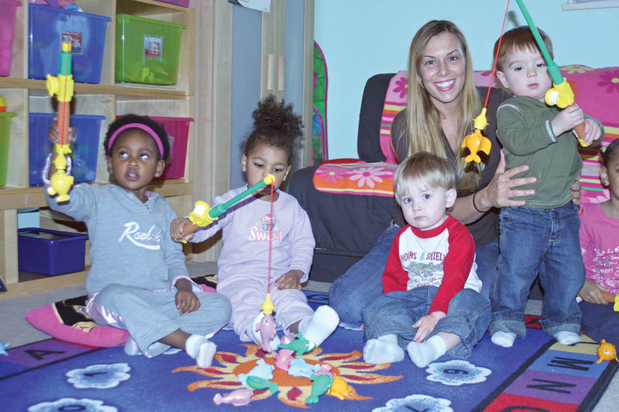 Family Child Care Provider Valentina Jones watches some of the children in her care take a make believe fishing trip. Catching plastic fish are, from left, Ayalah Anderson, 3; Jasmine Jones, 2; Adam Whitby, 1; and Luke Archer, 1. Mrs. Jones was recently named FCC Provider of the Quarter. (Air Force photo/Becky Pillifant) 
