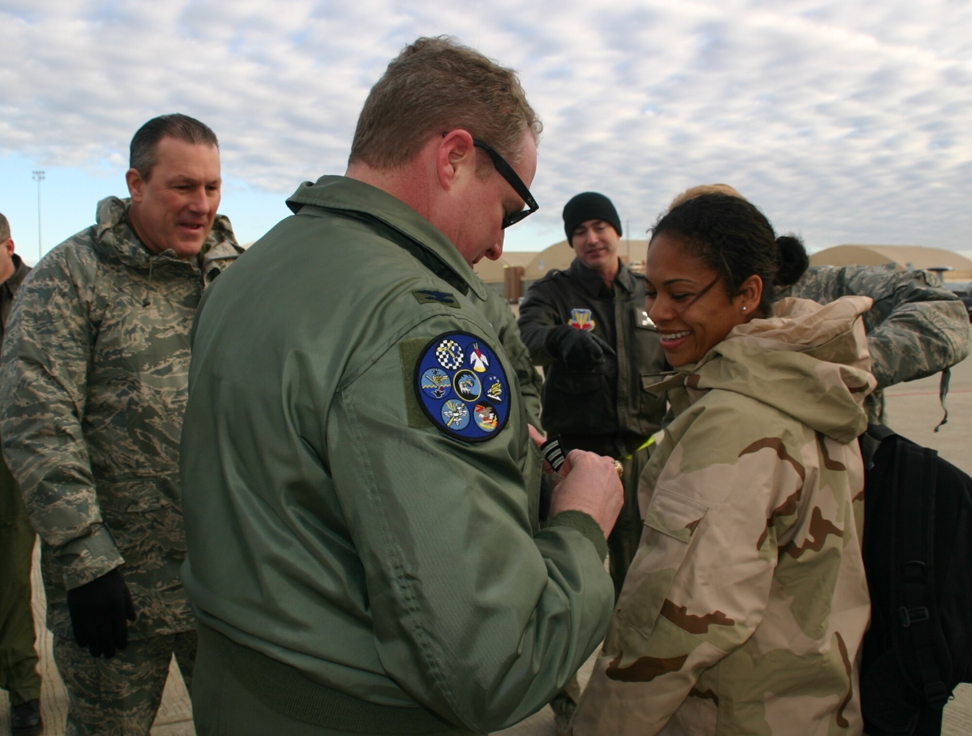 Staff Sergeant Nicole Copeland, 552nd Operations Support Squadron, is awarded her stripe by Col. George Carpenter, commander, 552nd Operations Group, as she disembarked the jet that brought her back from her latest deployment January 14, 2009. 