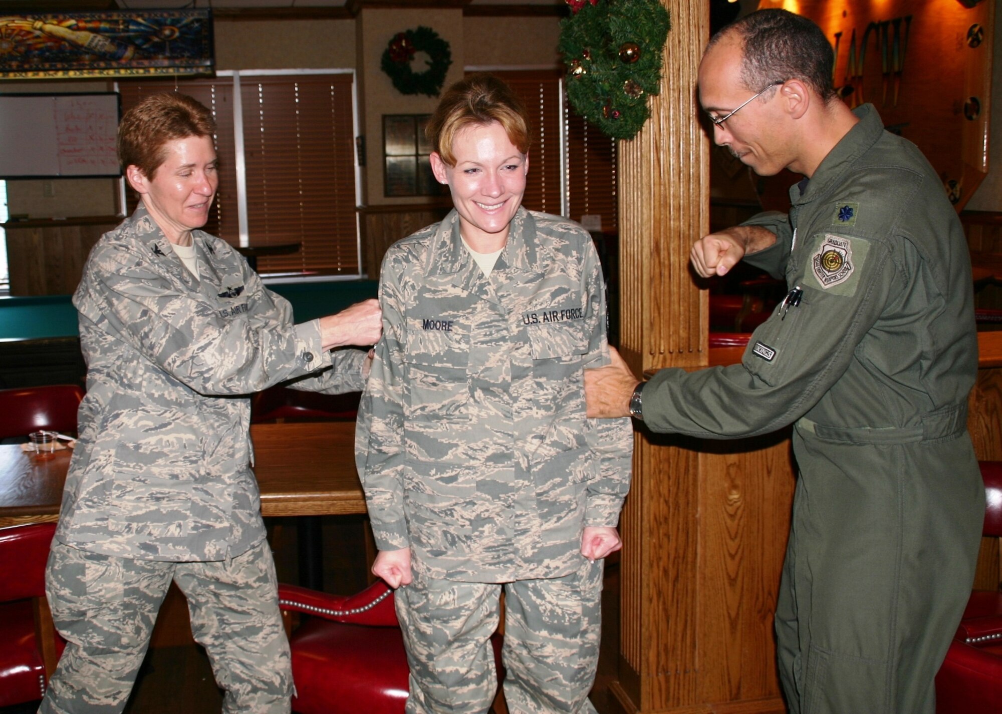Technical Sergeant Rachel Moore, 552nd Air Control Wing, was caught off guard at the Wing Staff Holiday Party with a stripe promoting her to master sergeant for her consistent record of excellence. Col. Pat Hoffman, commander, 552 ACW, and Lieutenant Col. Carson Elmore, director of staff, 552 ACW give her the traditional congratulatory punch.