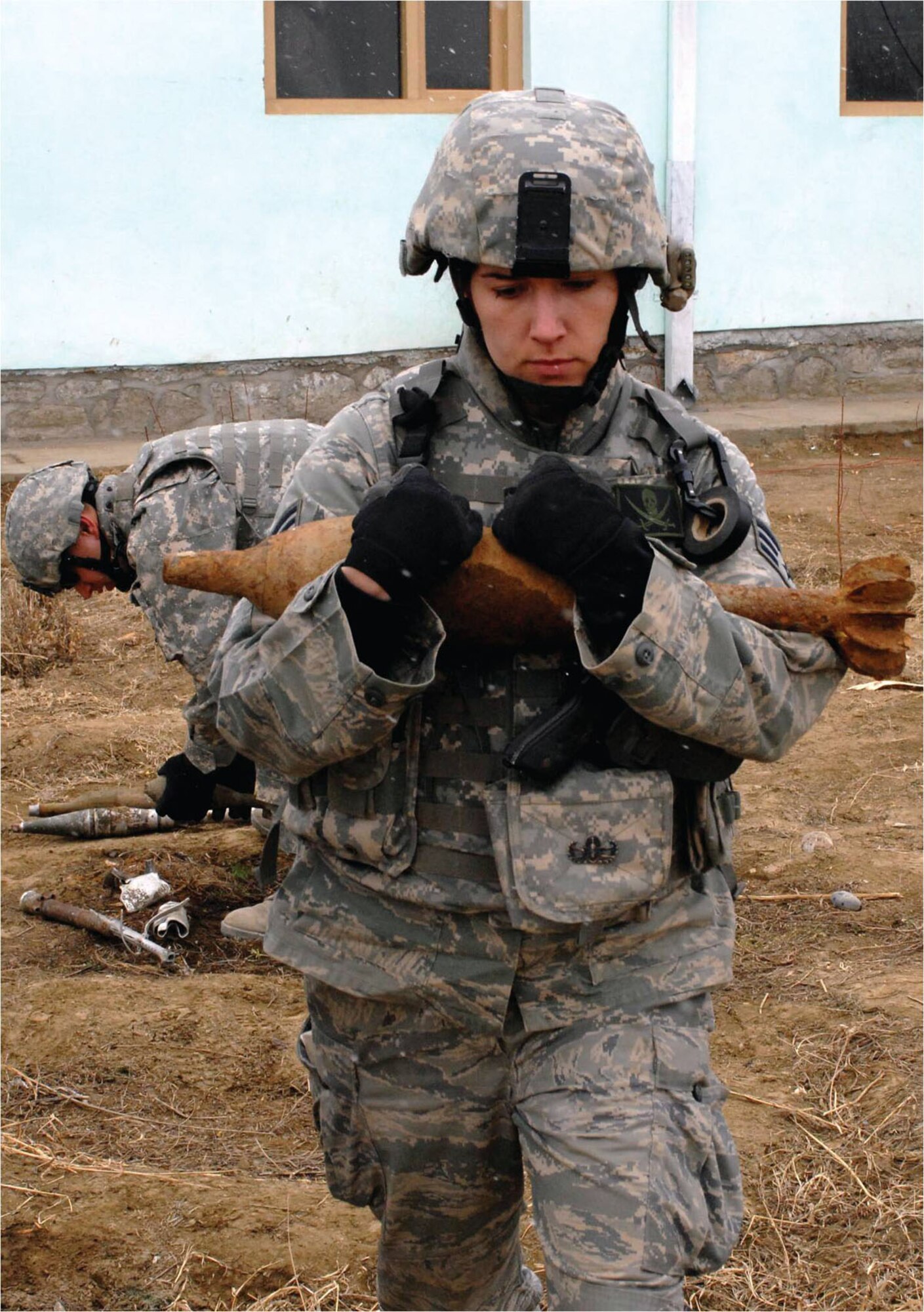 Senior Airman Sarah Snyder cradles an unexploded ordnance as she carries it to the joint explosive ordnance rapid response vehicle at a village in Afghanistan. Airman Snyder is an Explosive Ordnance journeyman with the 341st Civil Engnieer Squadron. (Courtesy photo)