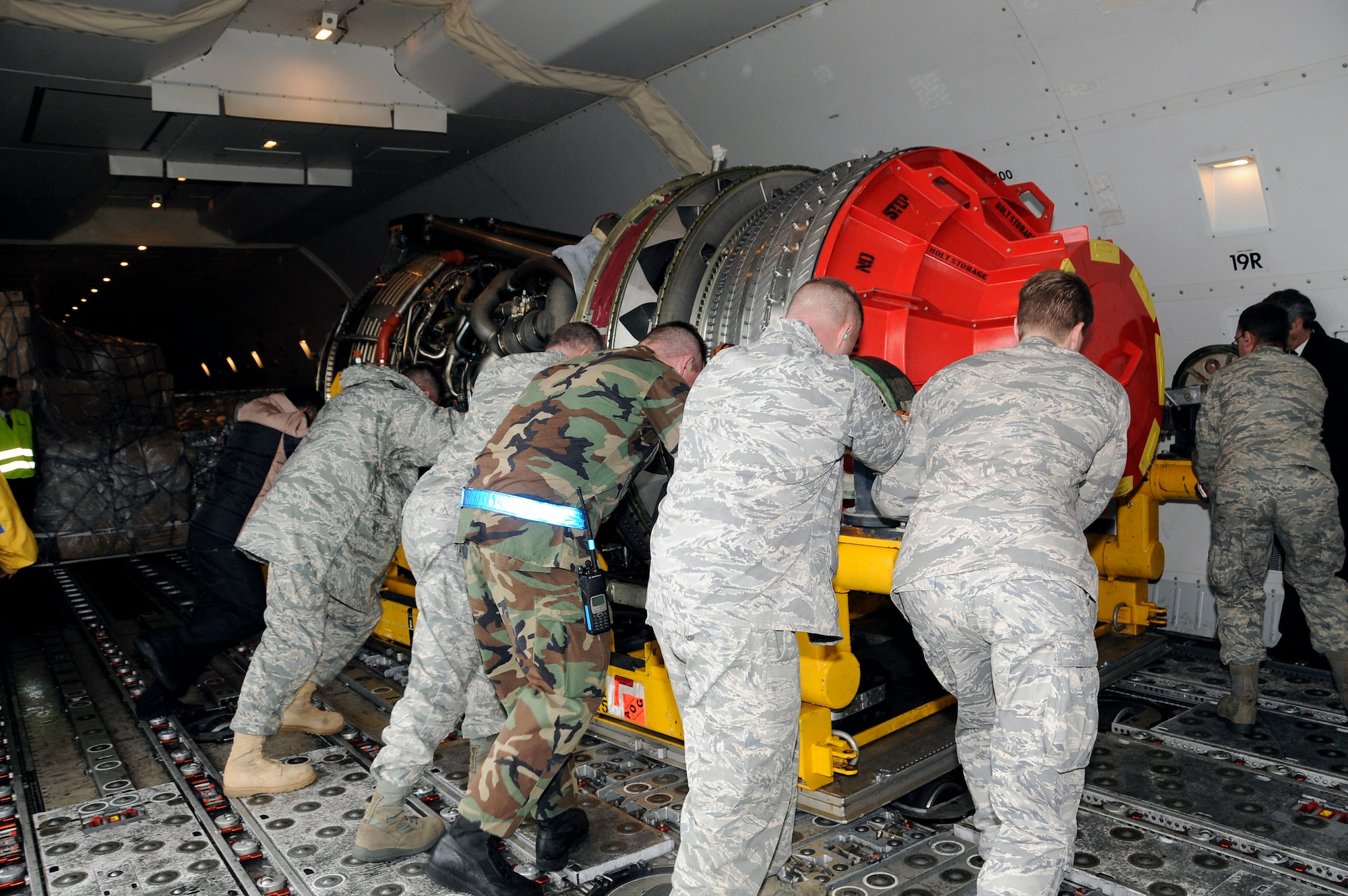 Members of the 729th Air Mobility Squadron push a defective engine into place on an Air France 747 cargo plane Jan. 13 at Lajes Field, Azores. Base members assisted the Portuguese and Air France officials in unloading a new engine for an Air France 777 passenger aircraft that made an emergency landing here Jan. 4. Airman Harrison and Sergeant Pieper are assigned to the 729th Air Mobility Squadron. (U.S. Air Force photo/Tech. Sgt. Rebecca Corey) 
