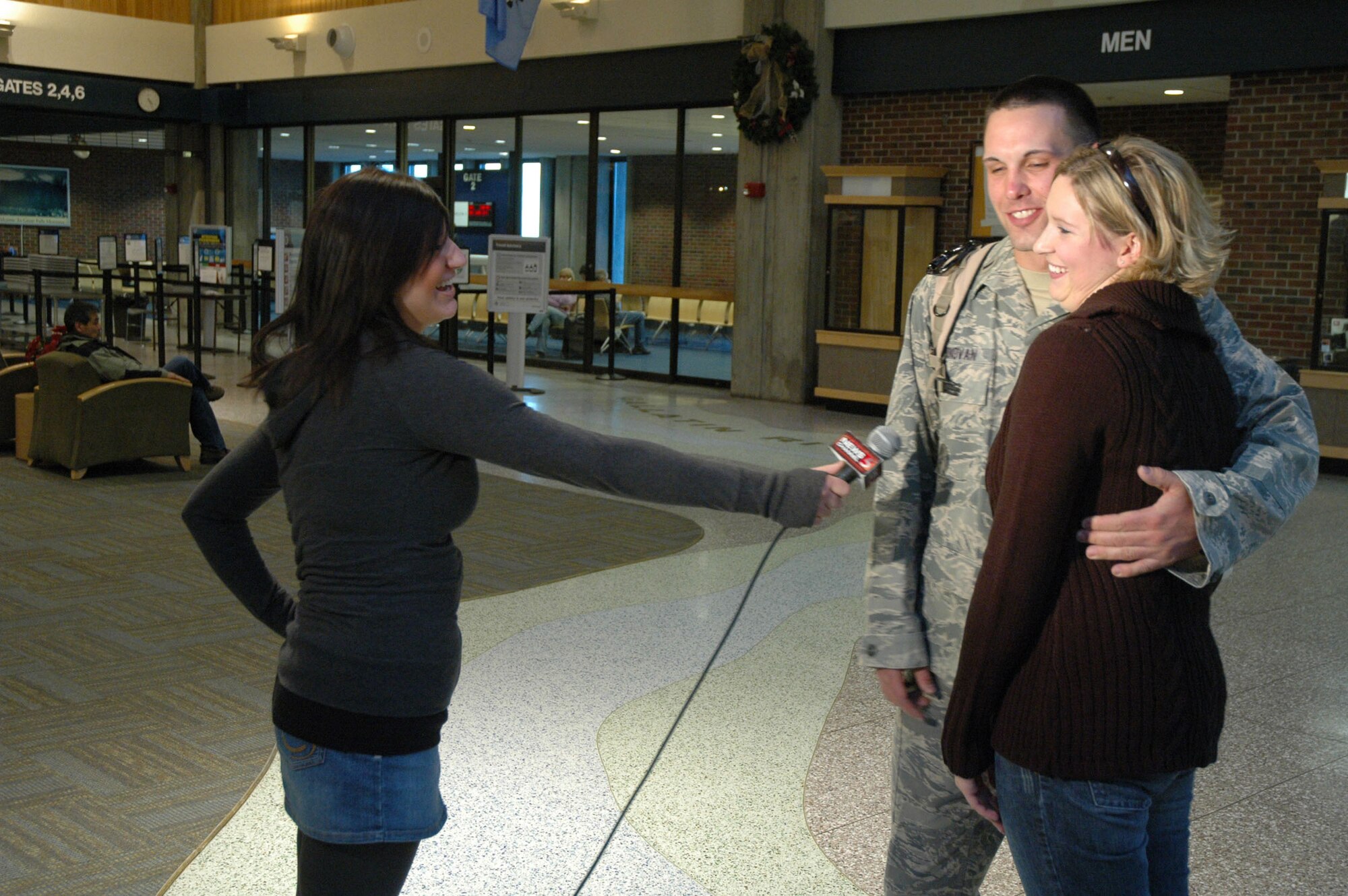 1Lt. Luke Donovan and his girlfriend, Naomi, are interviewed by local media upon Lieutenant Donovan's return Jan. 7 from a six month deployment to Iraq. He was one of 25 341st Civil Engineers from Malmstrom that returned that day. (U.S. Air Force photo/Senior Airman Dillon White)