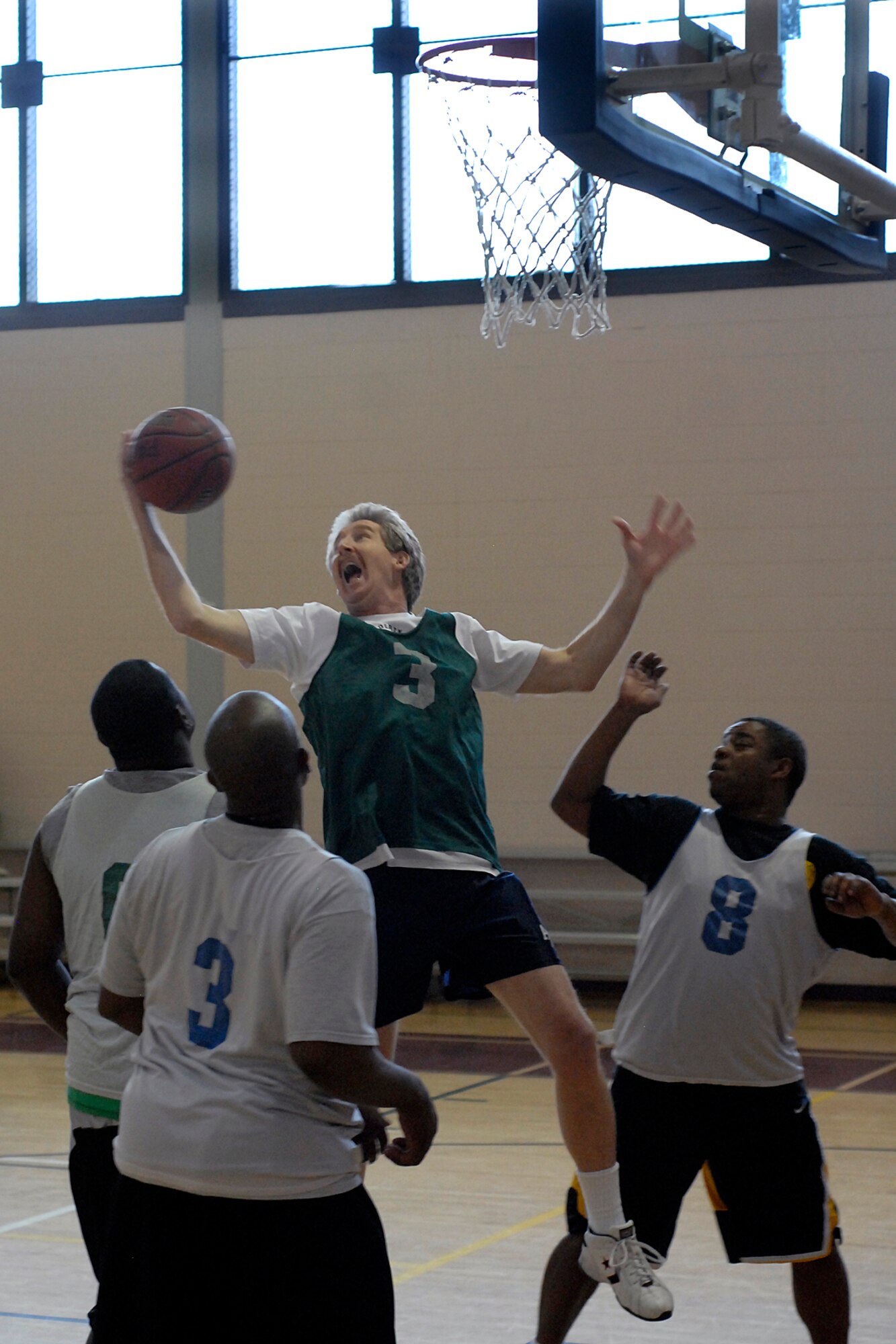 Peterson's 21st Force Support Squadron intramural basketball players skillfully defend a NORTHCOM J2 player attempting a lay up shot in a heated game at Gym 1 at the Fitness Center Jan. 8. The FSS clinched a 54 to 51 victory in this game. (Air Force photo/Larry Hulst) 