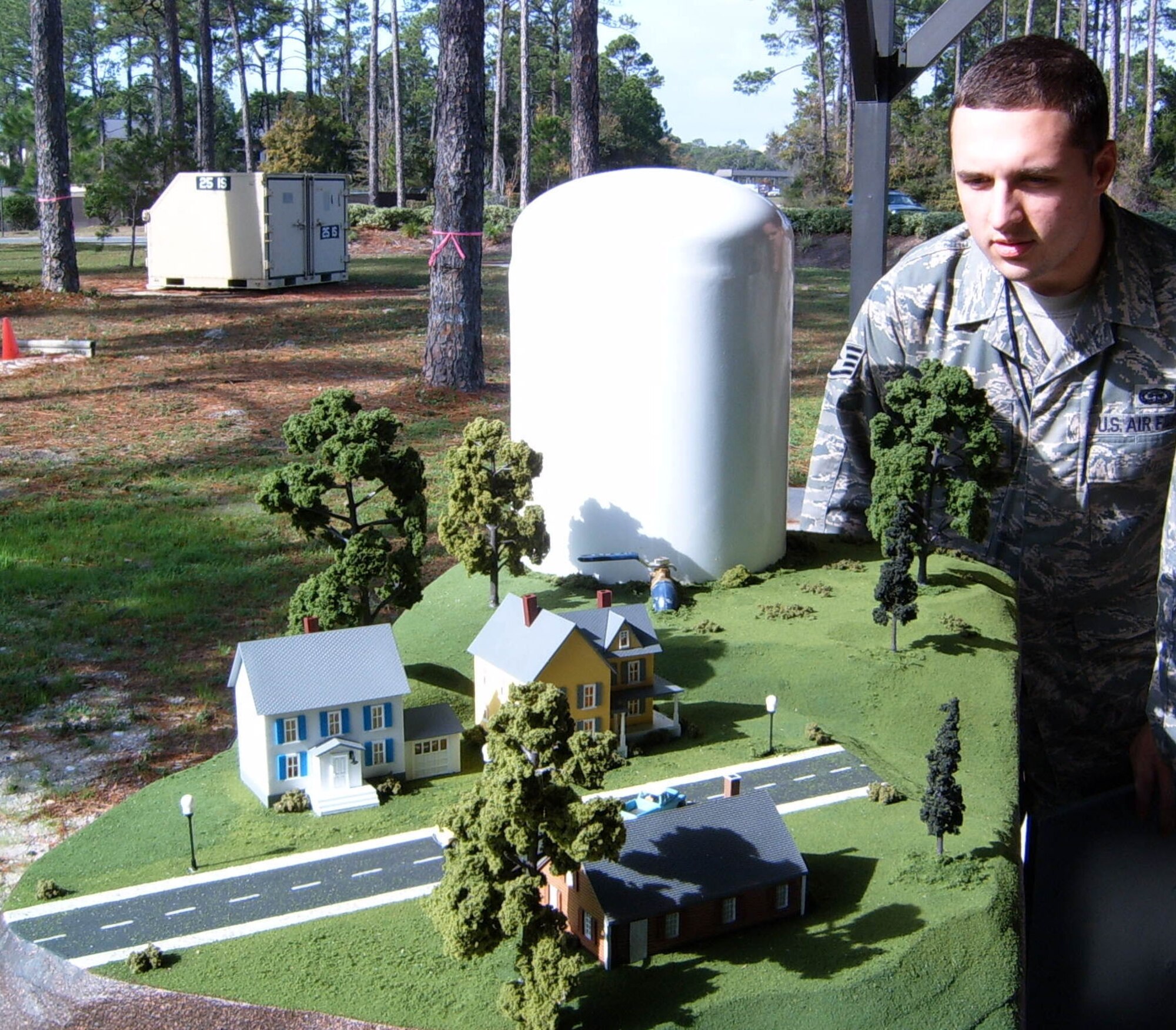 HURLBURT FIELD, Fla ?Students in the Undergraduate Network Warfare Training course at the 39th Information Operations Squadron inspect a model town used in an experiment to depict what could occur if a hacker invaded a water distribution plant?s control network.An off picture laptop acts as a human machine interface that serves to show water supply operators a graphic representation of the overall status of the water distribution.  The simulated hacker was successful in this scenario and caused the water tank to overflow but still showed operators that everything was normal. UNWT represents the most comprehensive network warfare training available in the Air Force and graduated its fifth class Dec. 19. (U.S. Air Force photo/ Capt. Ashley Conner)