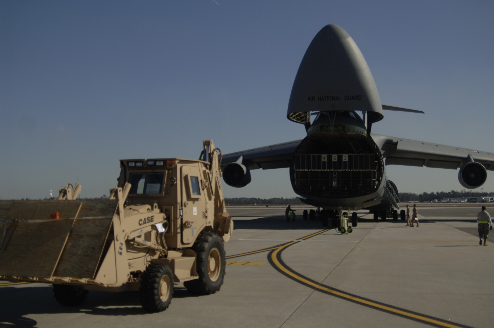 Airmen prepare to load a third-generation High Mobility Engineering Excavator onto a C-5 as it lowers to the ground to begin loading procedures on the Charleston AFB flightline Jan. 14. A total of eight third-generation HMEEs will be flown overseas to deployed locations in Southwest Asia to support Operation Enduring Freedom. (U.S. Air Force photo/Senior Airman Timothy Taylor)