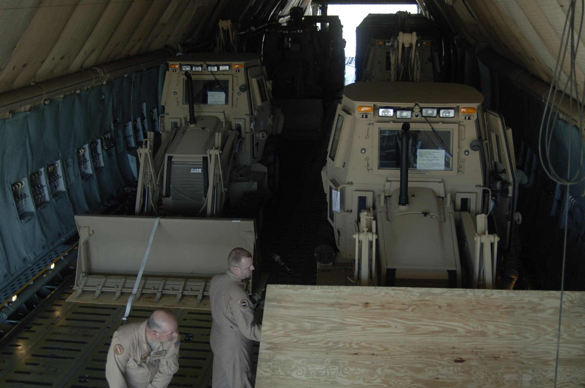 Airmen secure third-generation High Mobility Engineering Excavators to the floor of a C-5 on the Charleston AFB flightline Jan. 14. A total of eight third-generation HMEEs will be flown overseas to deployed locations in Southwest Asia to support Operation Enduring Freedom. (U.S. Air Force photo/Senior Airman Timothy Taylor)