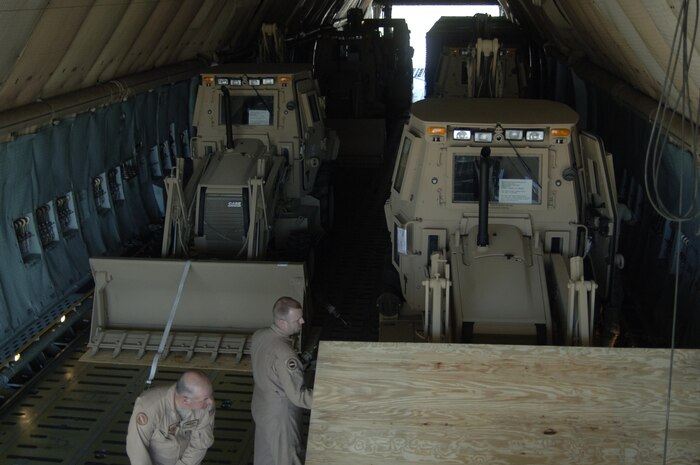 Airmen secure third-generation High Mobility Engineering Excavators to the floor of a C-5 on the Charleston AFB flightline Jan. 14. A total of eight third-generation HMEEs will be flown overseas to deployed locations in Southwest Asia to support Operation Enduring Freedom. (U.S. Air Force photo/Senior Airman Timothy Taylor)