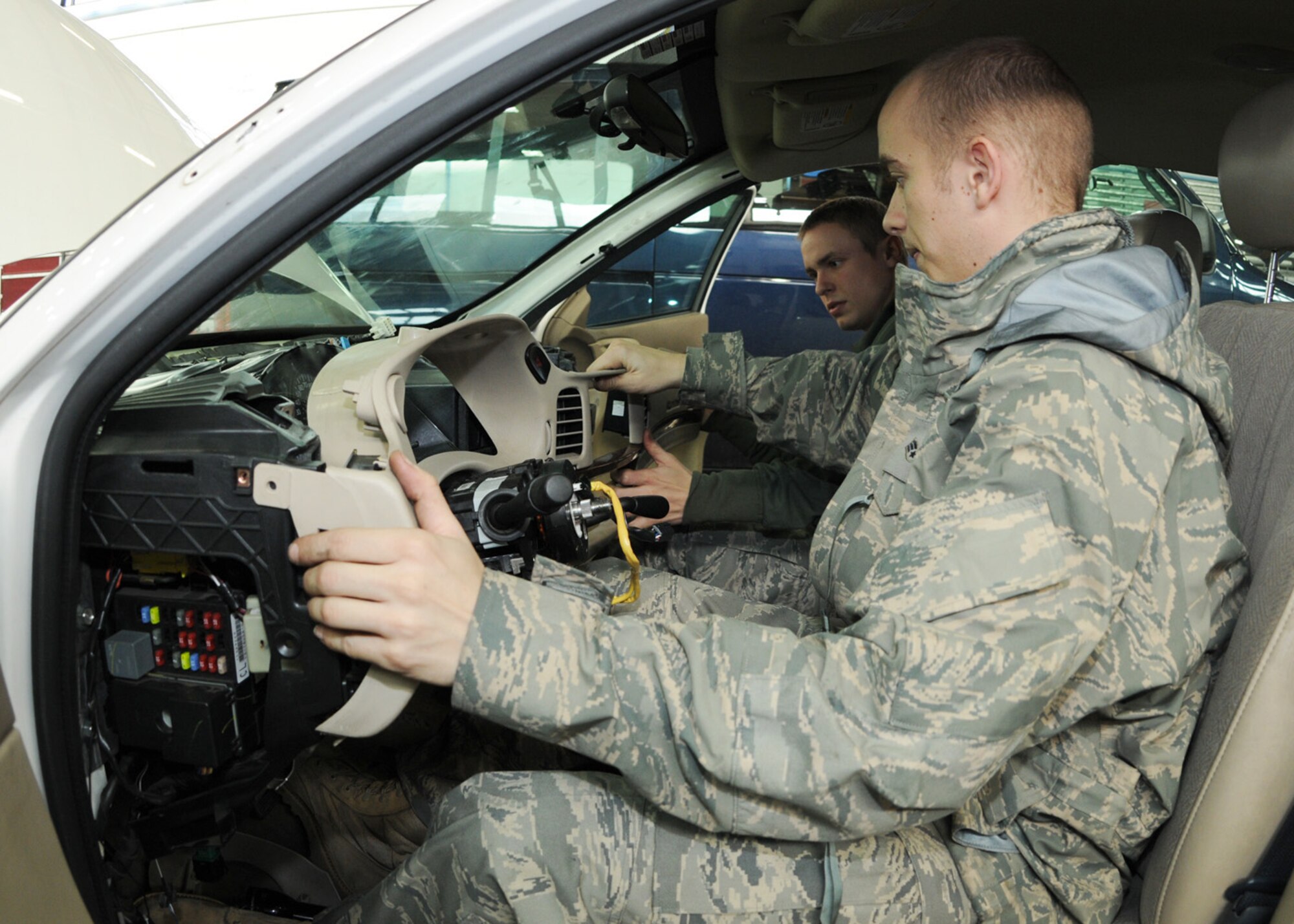 Senior Airman Johnny Ramsey, in the passenger seat, and Airman 1st Class Stephen Spears, both 100th Logistics Readiness Squadron vehicle maintenance technicians, install the dashboard inside a security forces vehicle after replacing the heater core Dec. 18, 2008, at RAF Mildenhall, England. The vehicle maintenance squadron performs annual inspections on more than 640 government vehicles at RAF Mildenhall, while also servicing and repairing vehicles daily. (U.S. Air Force photo by Staff Sgt. Jerry Fleshman) 