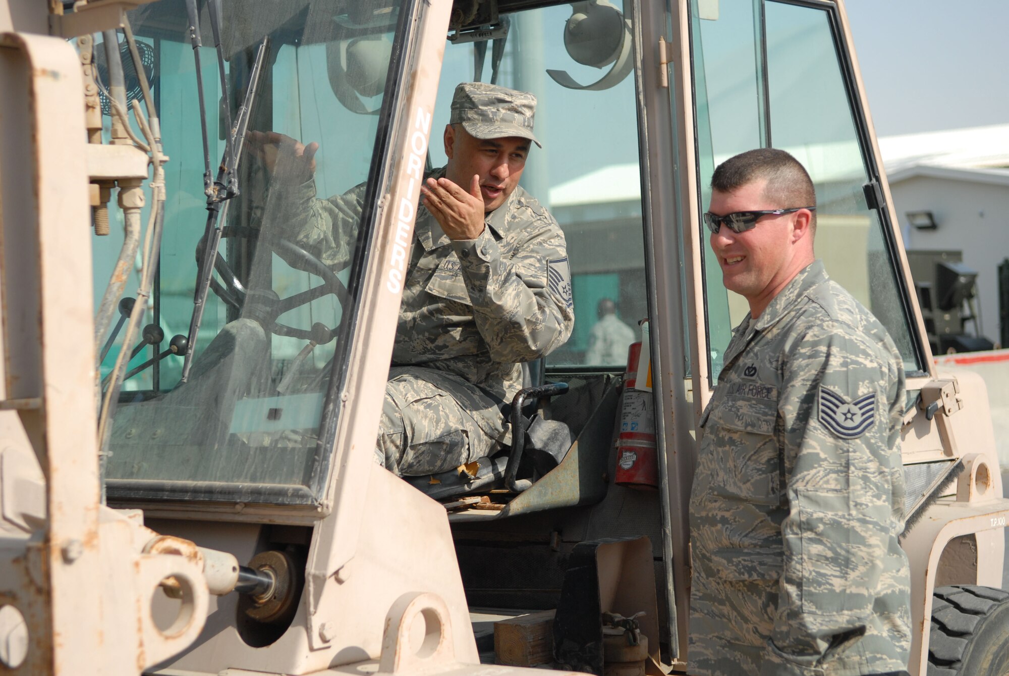 SOUTHWEST ASIA -- Master Sgt. Jose Cerna (left) and Tech. Sgt. Jeffery Montbriand discuss forklift placement of a frequency converter and uninterrupted power source in Hangar 4 here Jan. 10. Sergeant Montbriand, the electrical noncommissioned officer in charge of the operations flight, and Sergeant Cerna, the superintendent of the operations flight, are both with the 380th Expeditionary Civil Engineer Squadron. Although the electrical flight does not usually provide forklift support, both NCOs are qualified forklift drivers allowing them the fexibility to adapt to the needs of the deployed environment. Sergeant Montbriand is a Coventry, Conn., native. Sergeant Cerna hails from Del Rio, Texas. Both are deployed from Andrews Air Force Base, Md. (US Air Force photo by Tech. Sgt. Denise Johnson) (released)