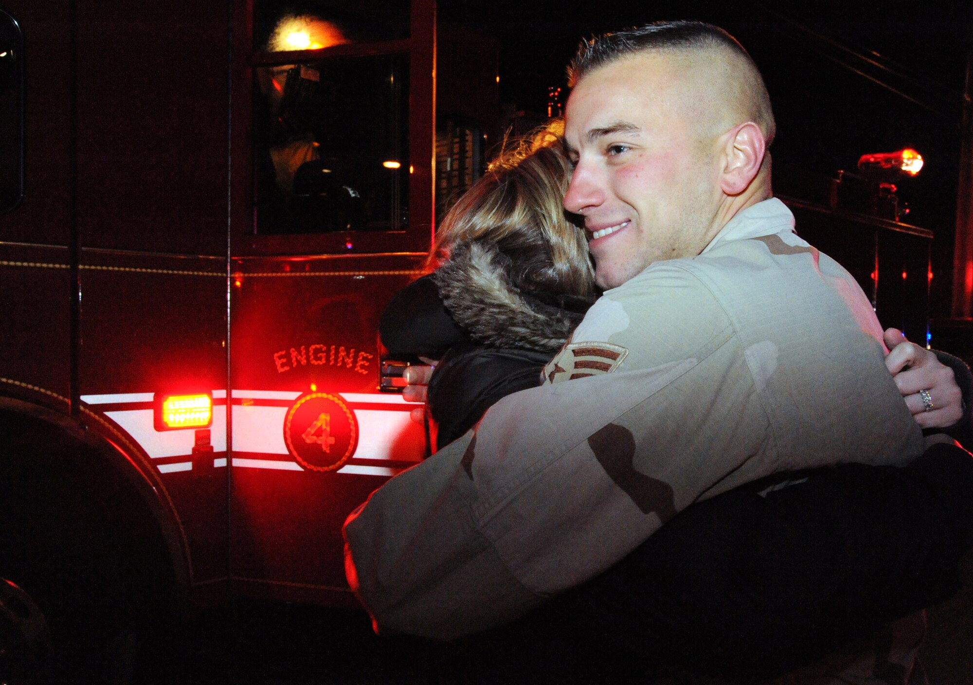 Senior Airman Derek Larson, 436th Civil Engineer Squadron and City of Dover volunteer firefighter, hugs his wife, Lindsay, upon arriving to his home in Dover Jan. 16. Airman Larson was credited with treating the gunshot wounds of two injured Iraqis during his deployment to Joint Base Balad, Iraq. (U.S. Air Force photo/Tech. Sgt. Kevin Wallace)