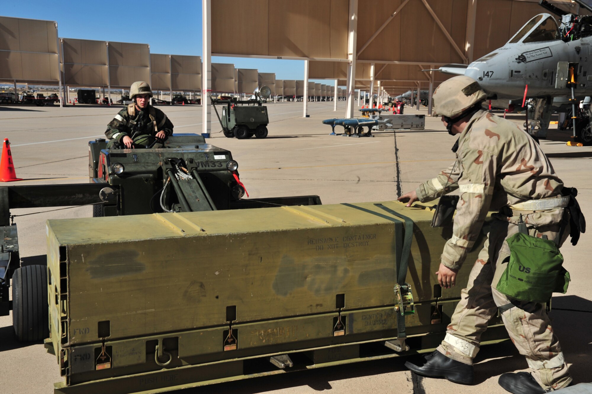 Staff Sgt. Brian Tucker (right) of the 355th Aircraft Maintenance Squadron guides Senior Airman Jacob Britton as he loads a missile container onto a forklift to move to next aircraft during the Phase II Operational Readiness Exercise here Jan. 14. (U.S. Air Force photo/Senior Airman Noah R. Johnson)