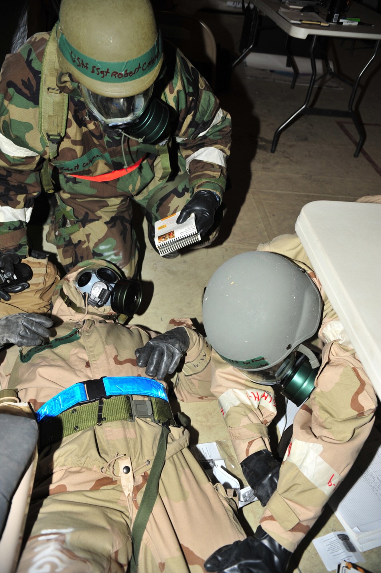 Airman 1st Class John Bullington (bottom right) of the 355th Logistics Readiness Squadron simulates injecting a nerve agent antidote into 1st Lt. Nicholas Downing, as Staff Sgt. Robert Coleman advises on proper procedures for self aid and buddy care during the Phase II Operational Readiness Exercise here Jan. 15. (U.S. Air Force photo/Senior Airman Noah R. Johnson)