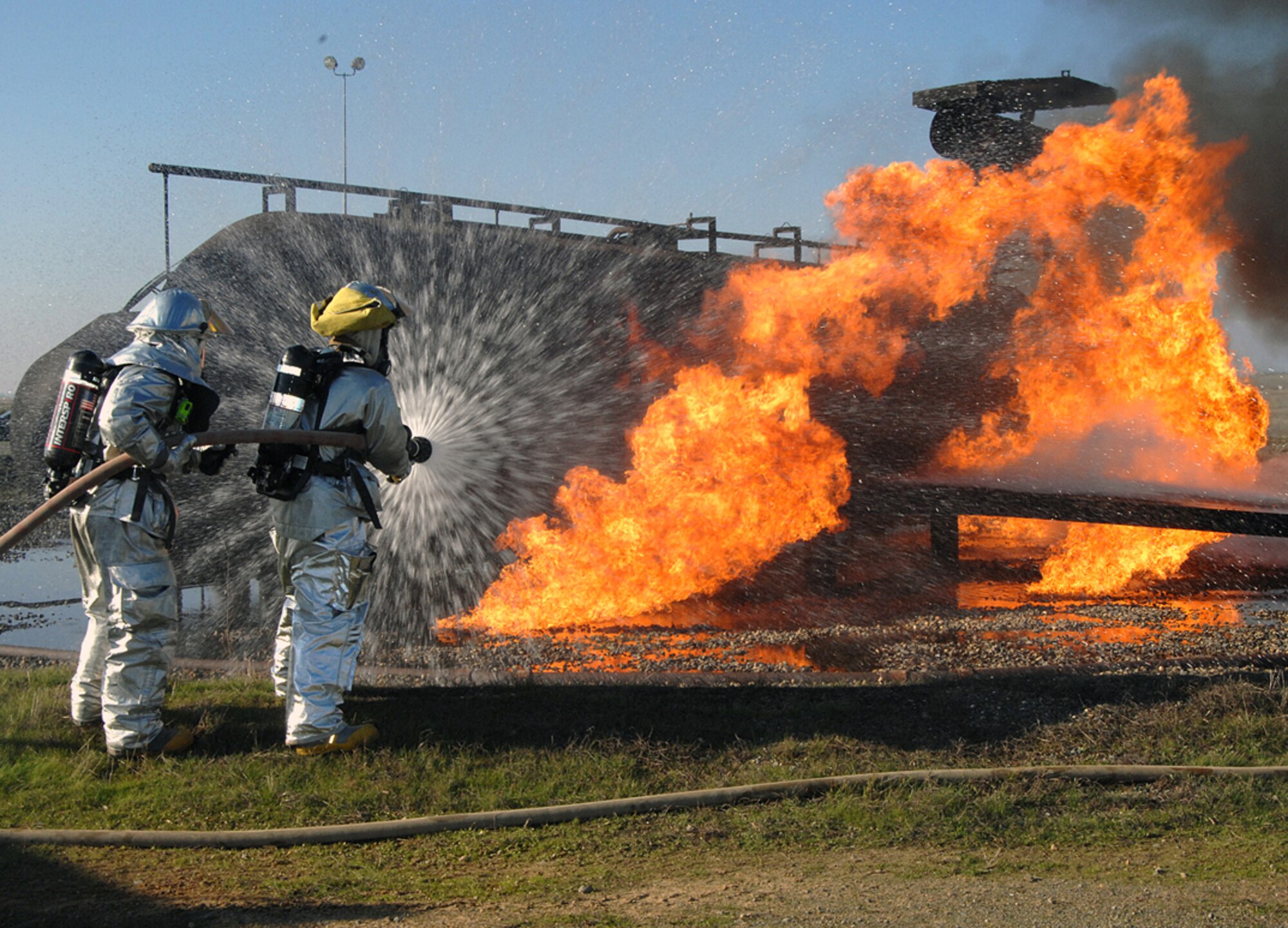 9th Civil Engineer Squadron fire fighters get up close and personal with a practice live fire during day 2 of the recent Phase II Operational Readines Exercise. (Photo by Sean Bhakta)